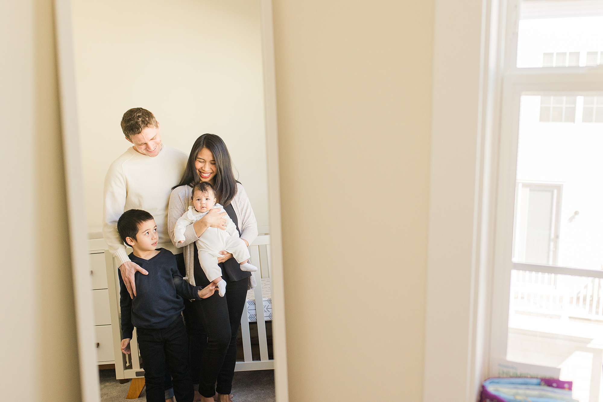 family of four stand in nursery during Silver Spring lifestyle family session