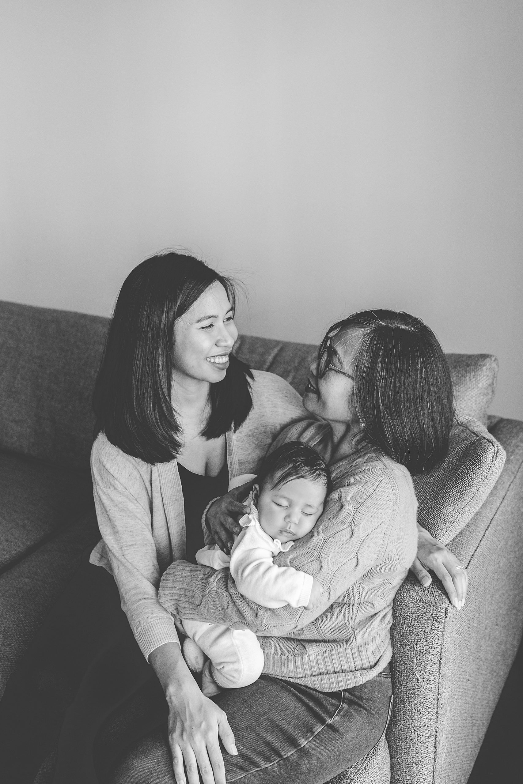 mom laughs with grandmother and daughter on couch during Silver Spring lifestyle family session