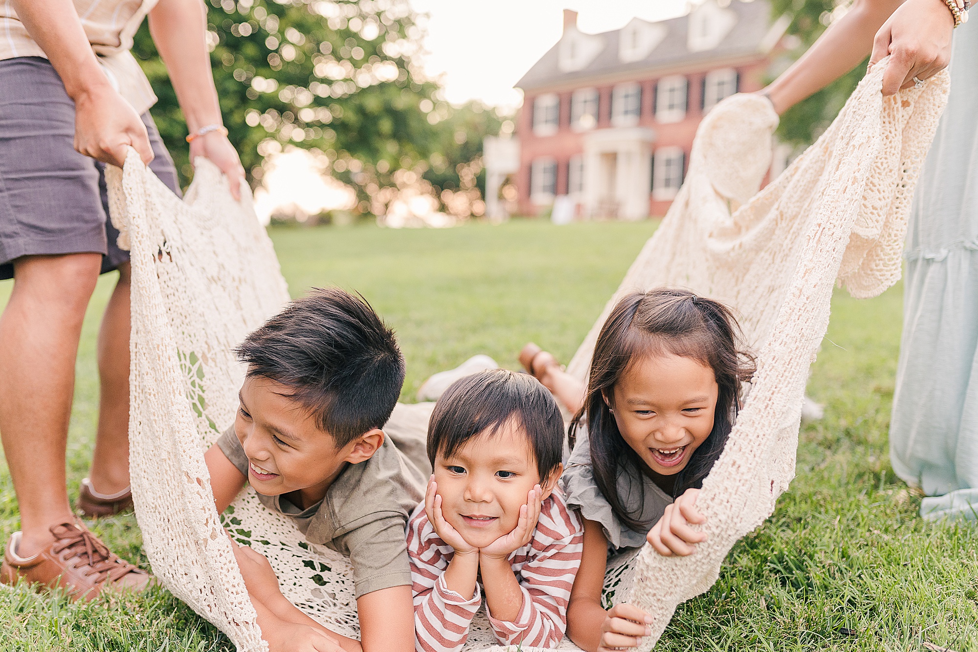 three kids play in blanket during Maryland family photos 