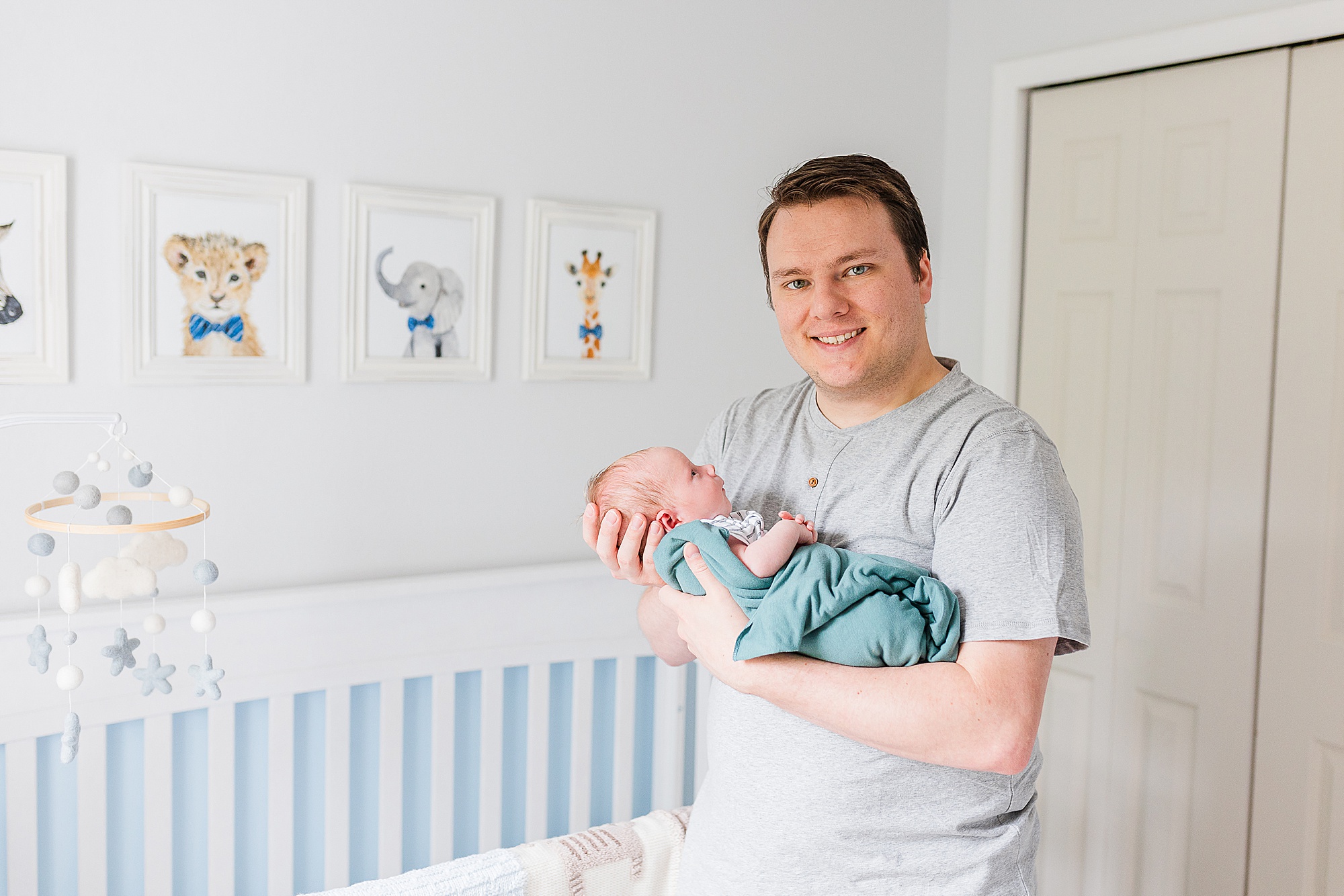 dad holds baby during newborn session at home