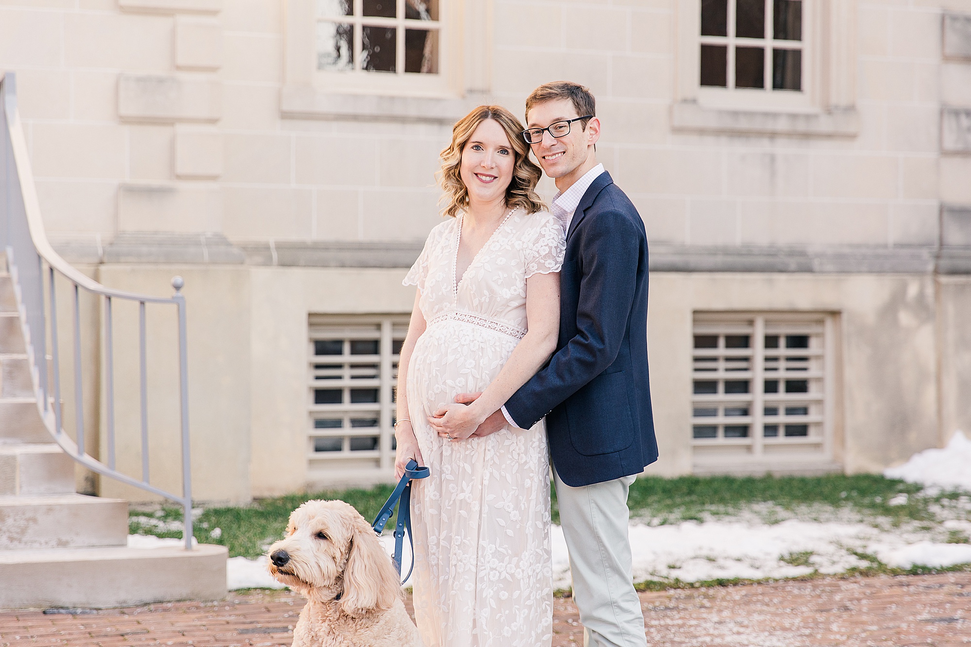 parents hug outside building  during maternity photos in Historic Alexandria VA