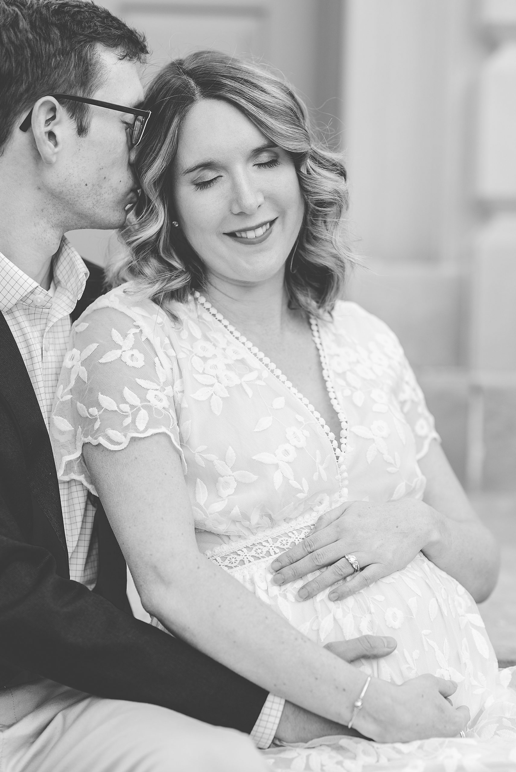 husband kisses wife's head during maternity session 