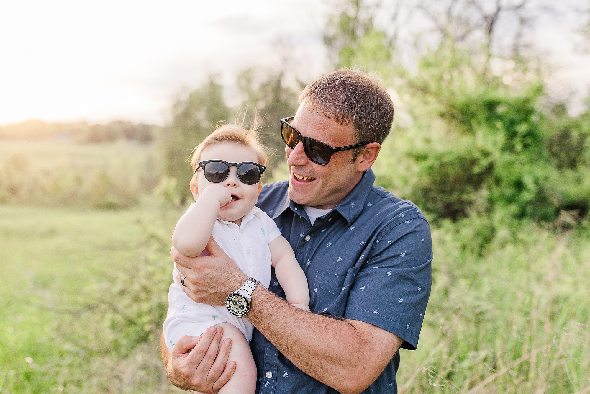 dad holds toddler wearing sunglasses during 6 Month Milestone Portraits at the Howard Conservancy