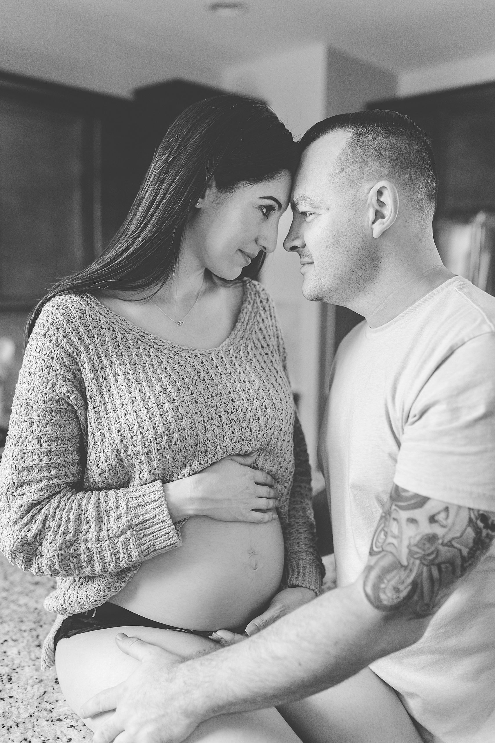 husband and wife pose in kitchen during MD maternity photos