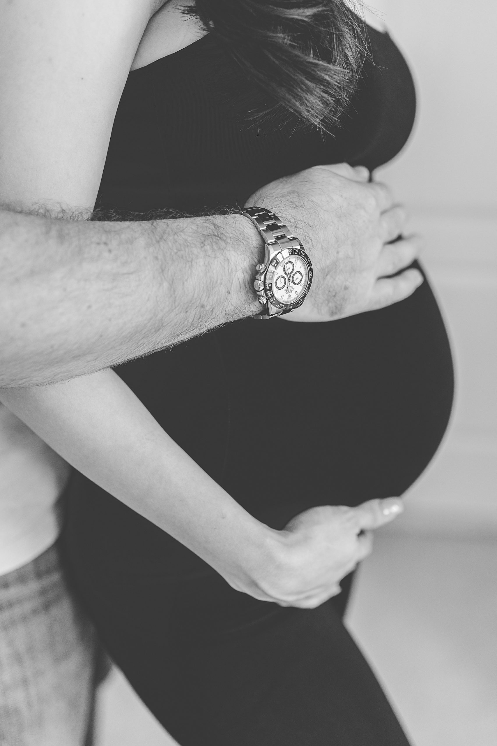 dad holds mom's belly during maternity session at home