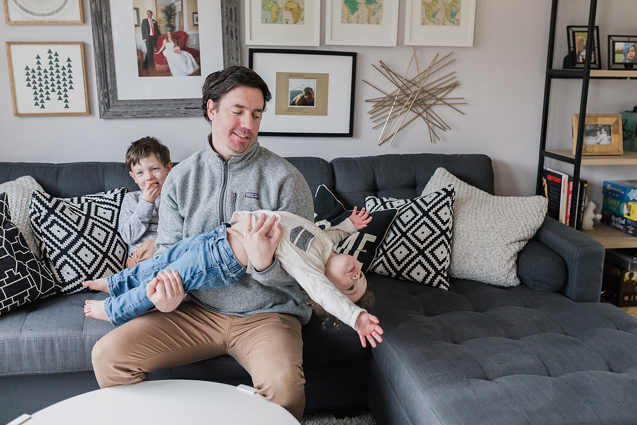 dad plays with son during family photos at home