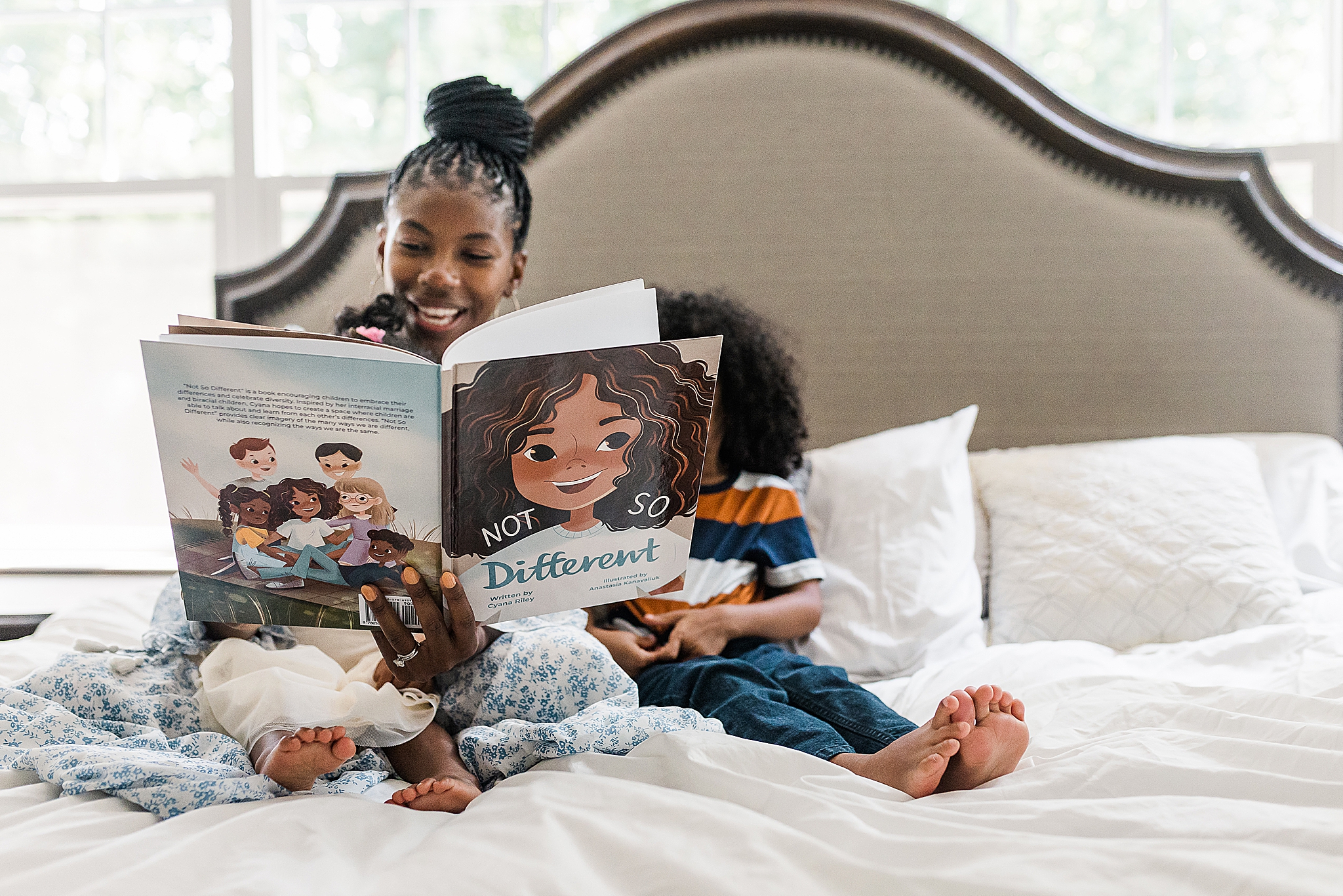 family reads book on bed during lifestyle photos in Maryland