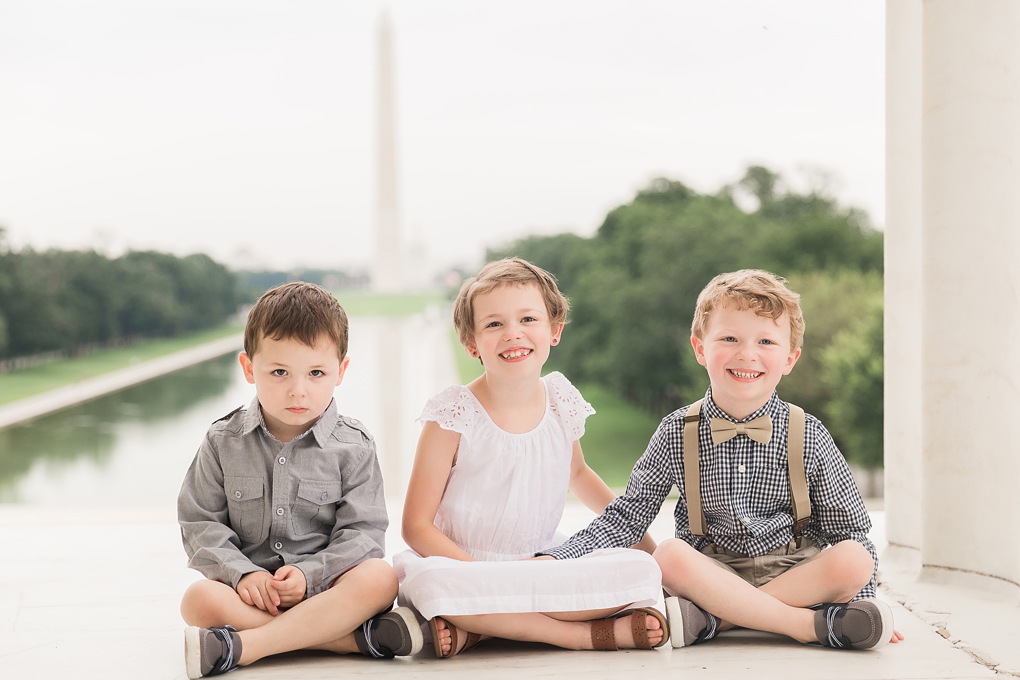 three kids sit on steps of Lincoln Memorial