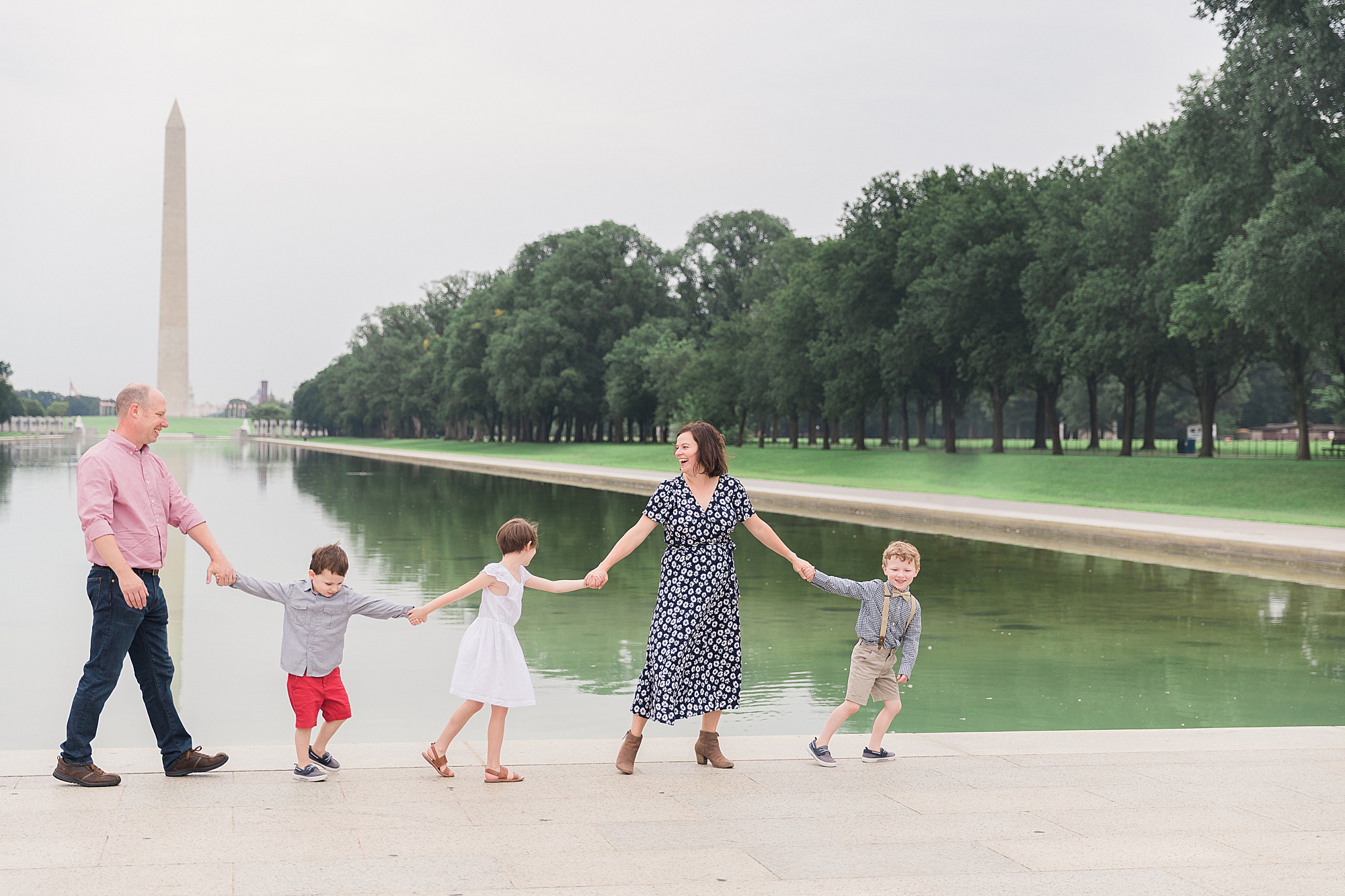 parents walk with three kids along Reflection Pool in DC