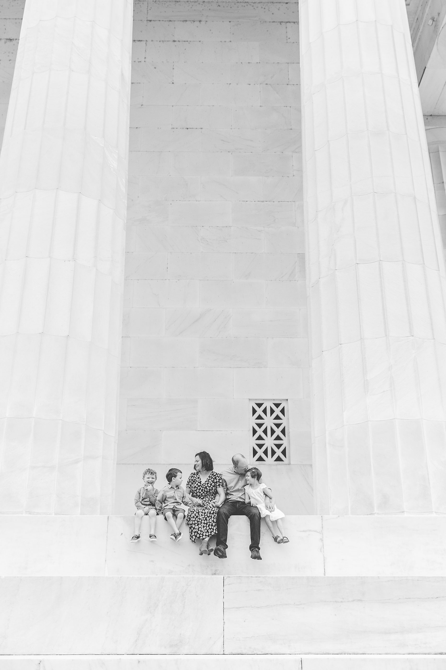 parents sit on steps of Lincoln Memorial with three kids
