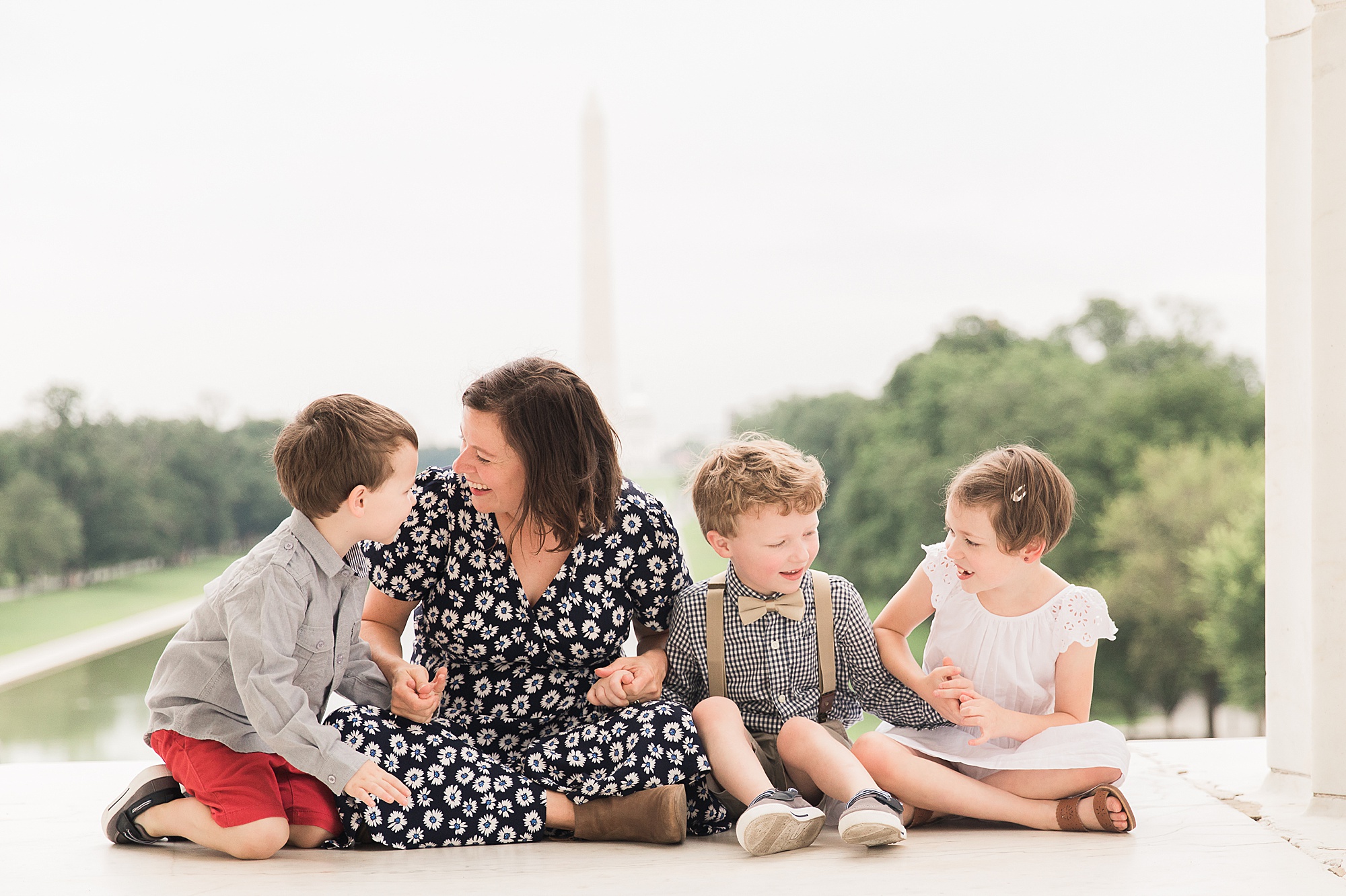 mom sits with three kids on steps of Lincoln Memorial