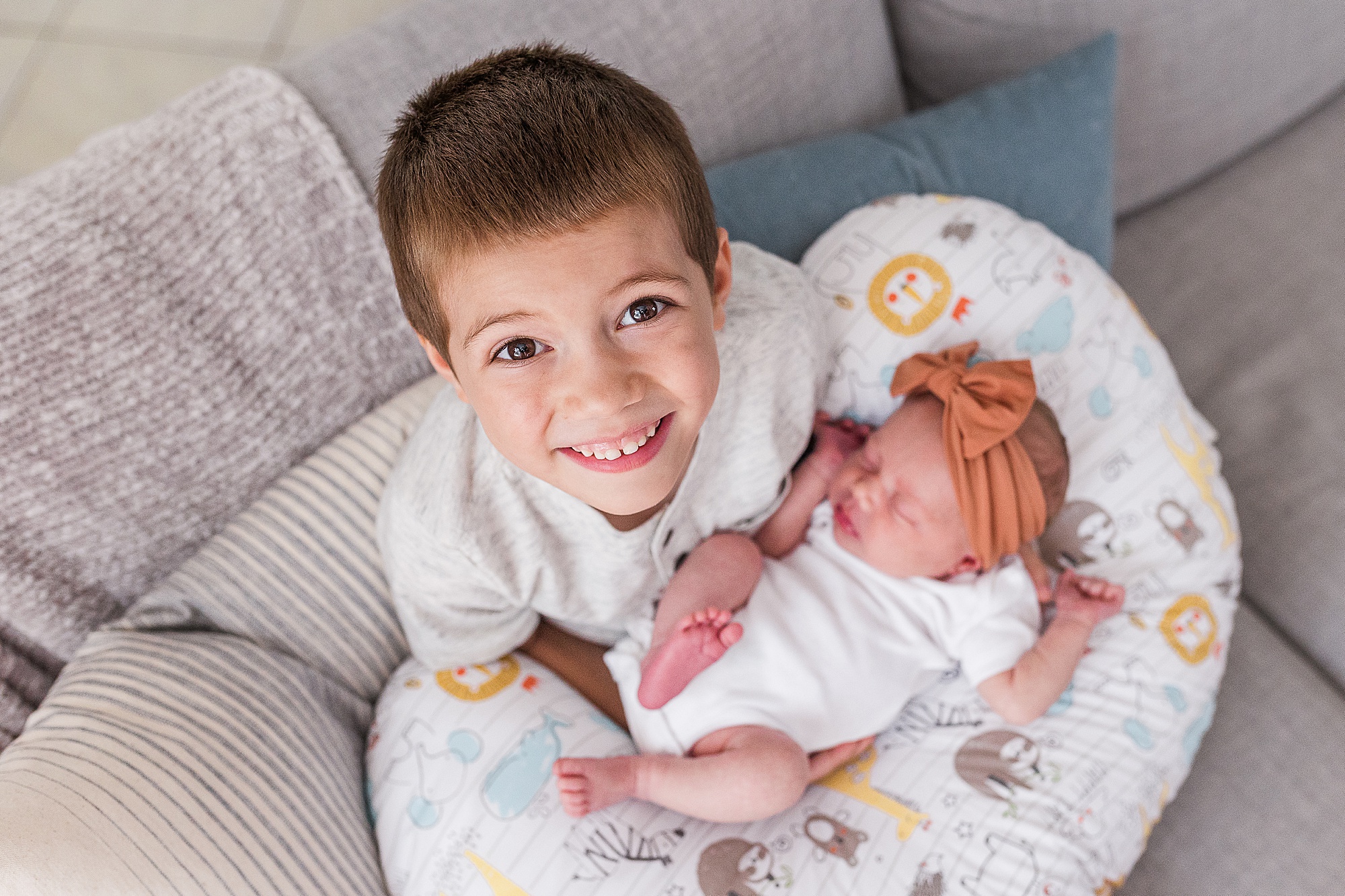 brother holds sister on boppi during newborn photos