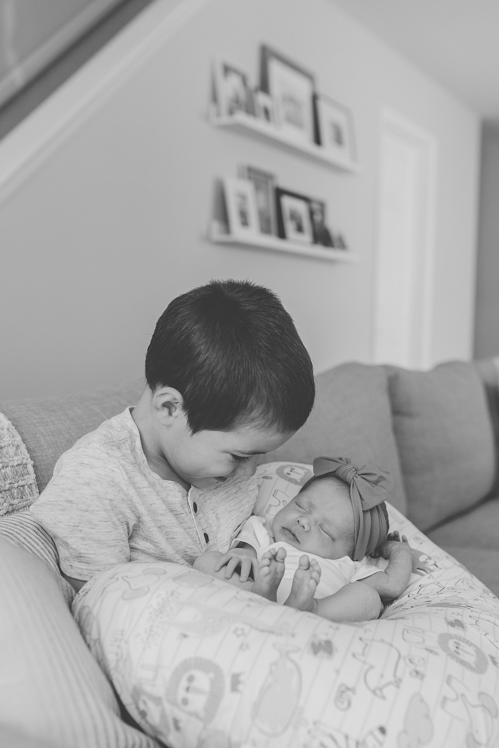 big brother holds new sister on couch at home 