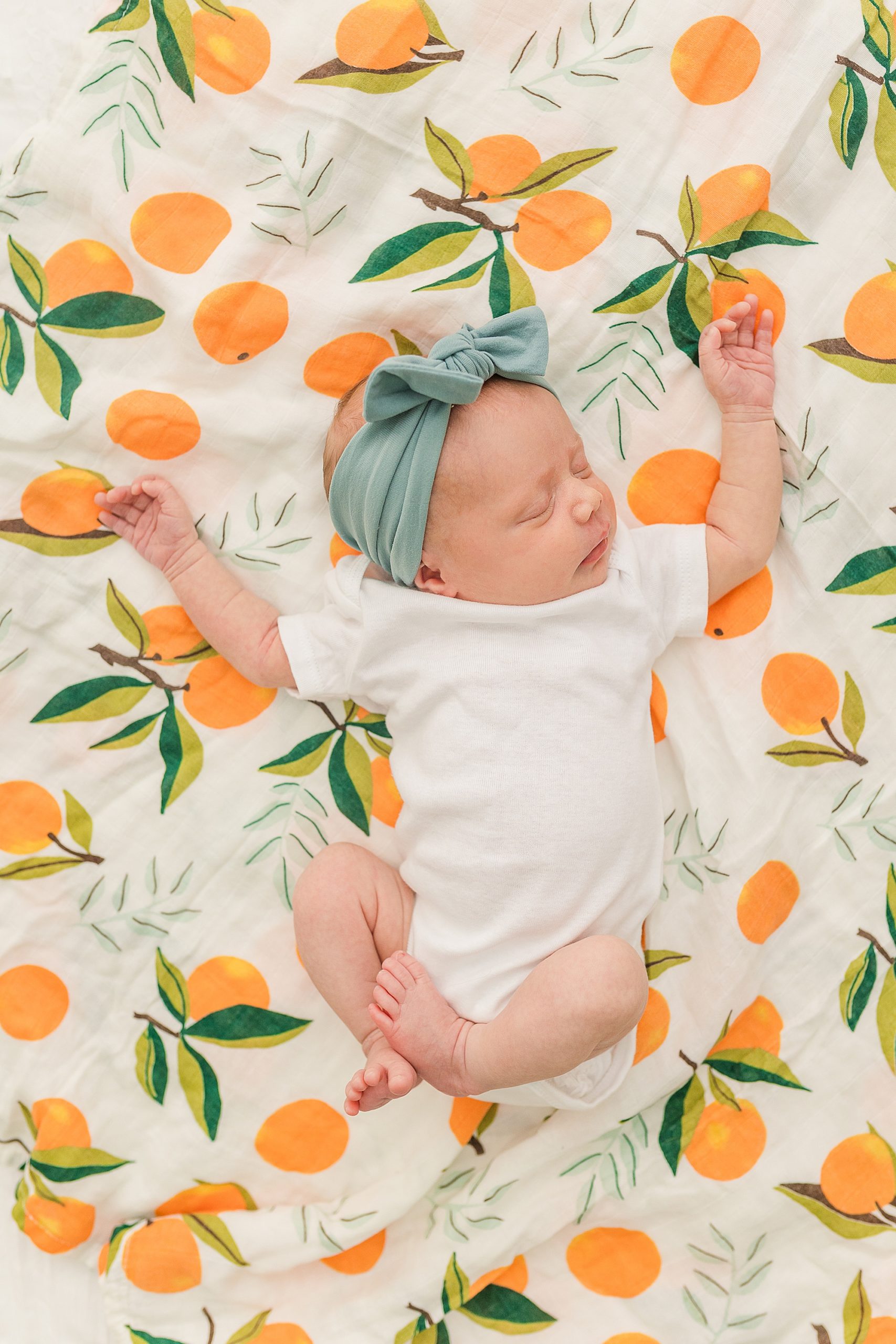 baby girl lays on citrus blanket at home 