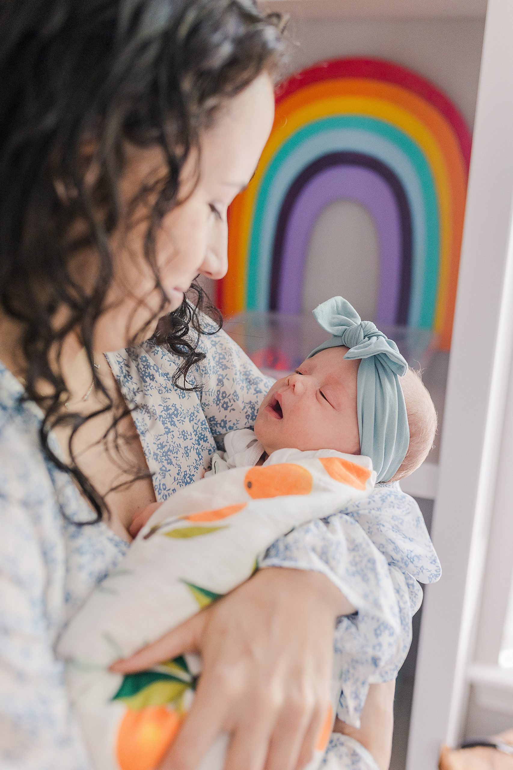 mom holds newborn girl in playroom at home