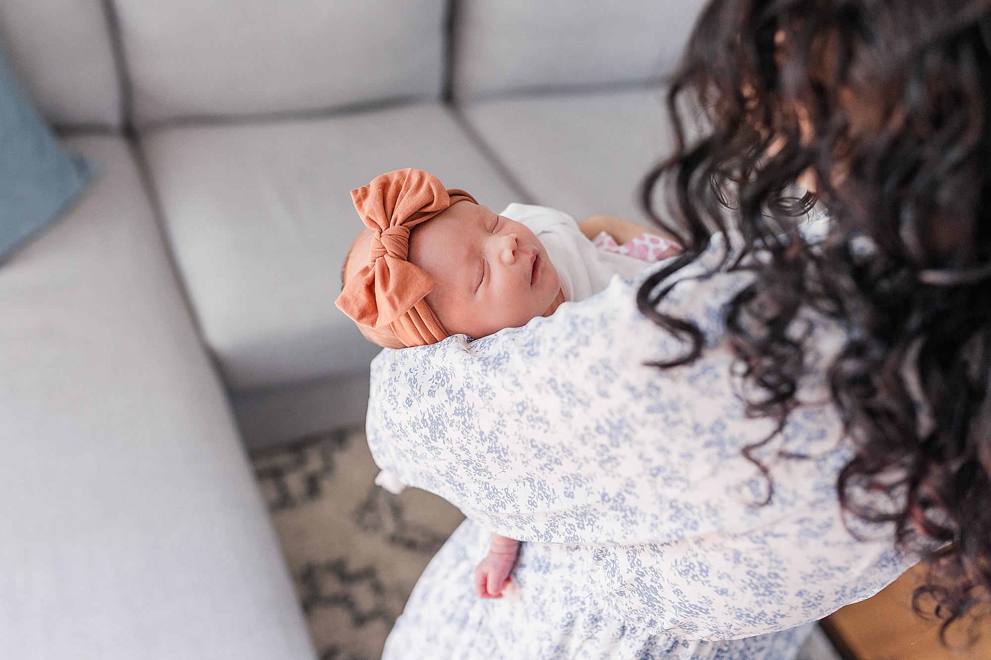 mom looks at baby girl with coral bow on head