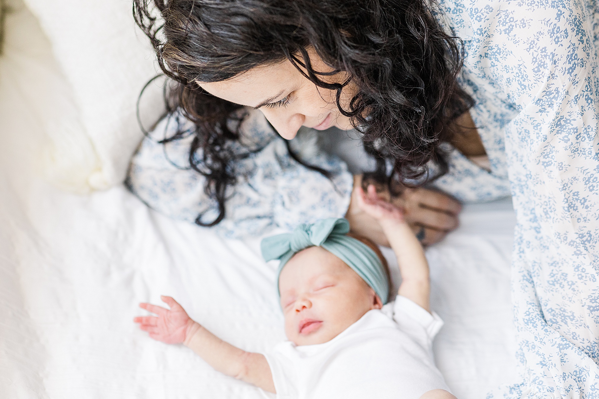 mom looks at baby girl on bed during Lifestyle Newborn Session in Annapolis