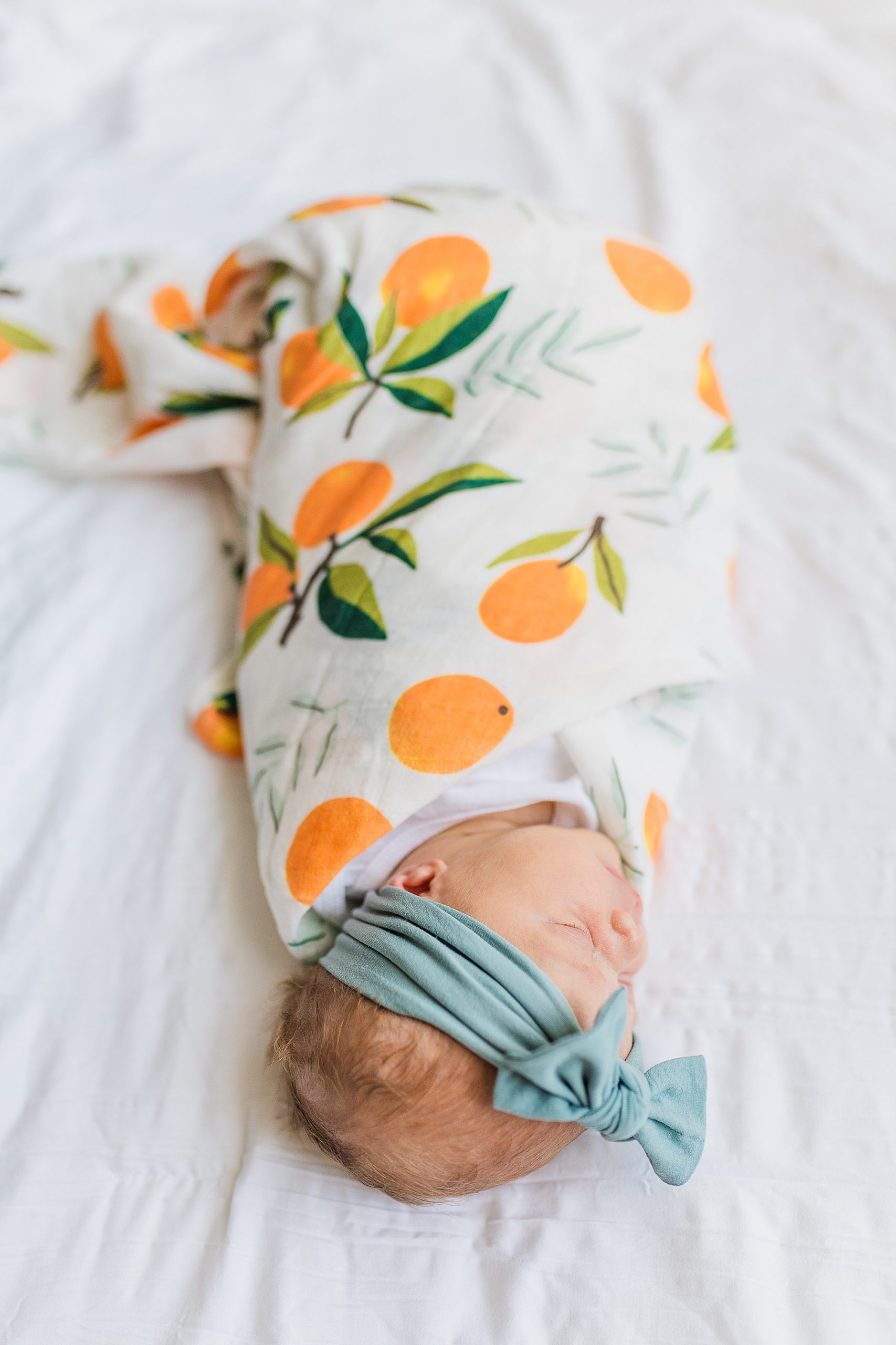 baby girl sleeps in citrus wrap with blue headband