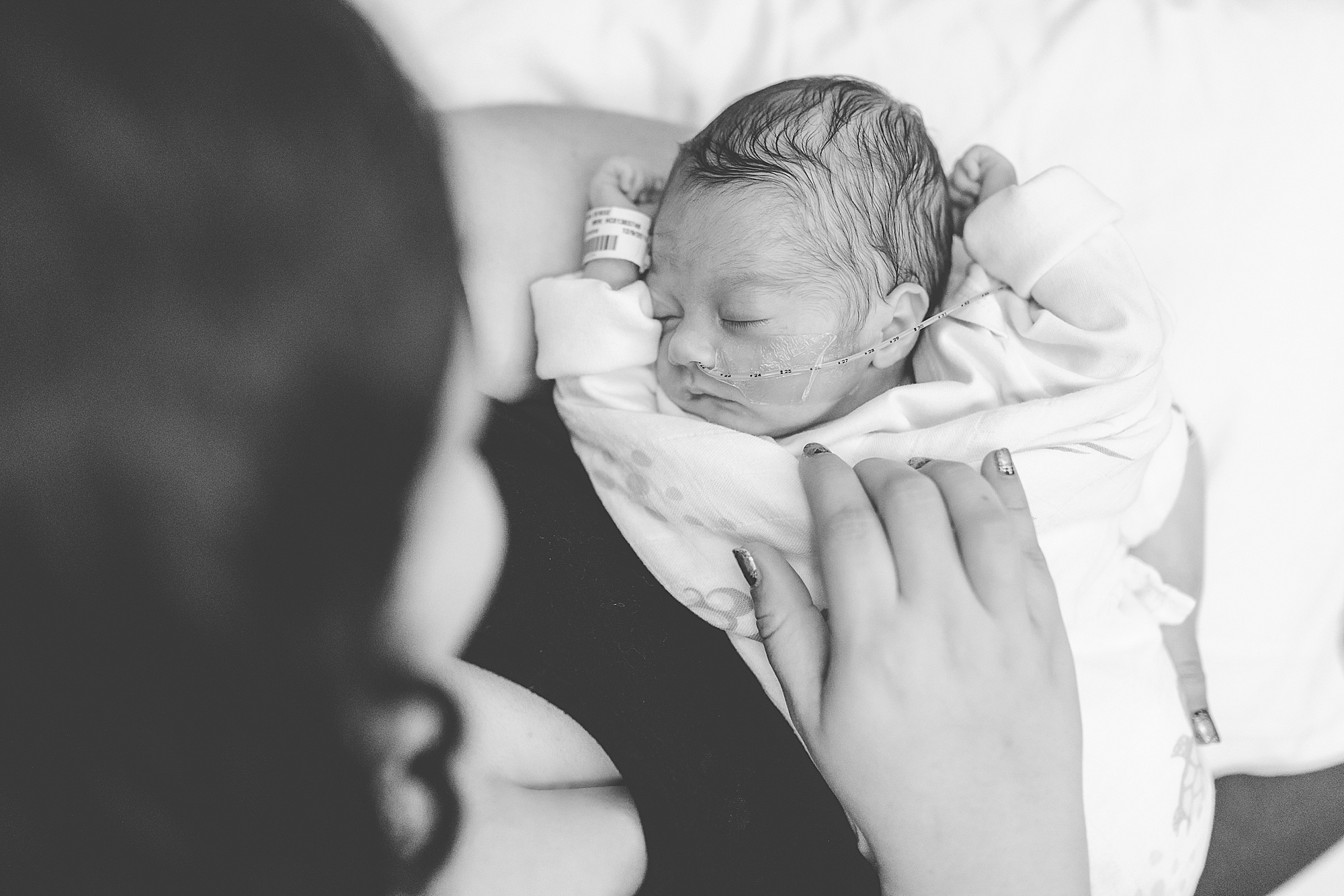 mom looks at baby girl sleeping during NICU newborn portraits