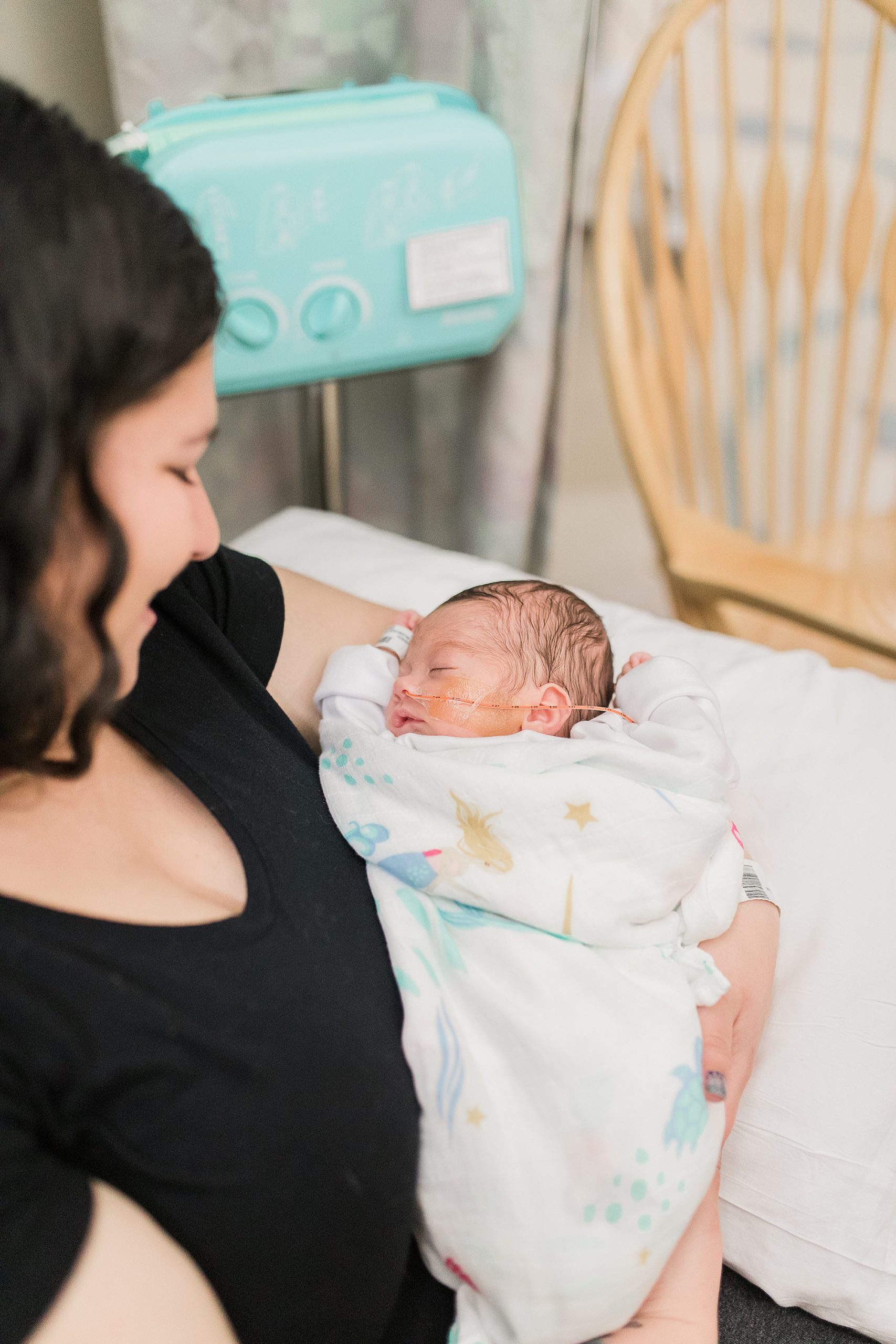 mom snuggles with daughter during NICU newborn portraits
