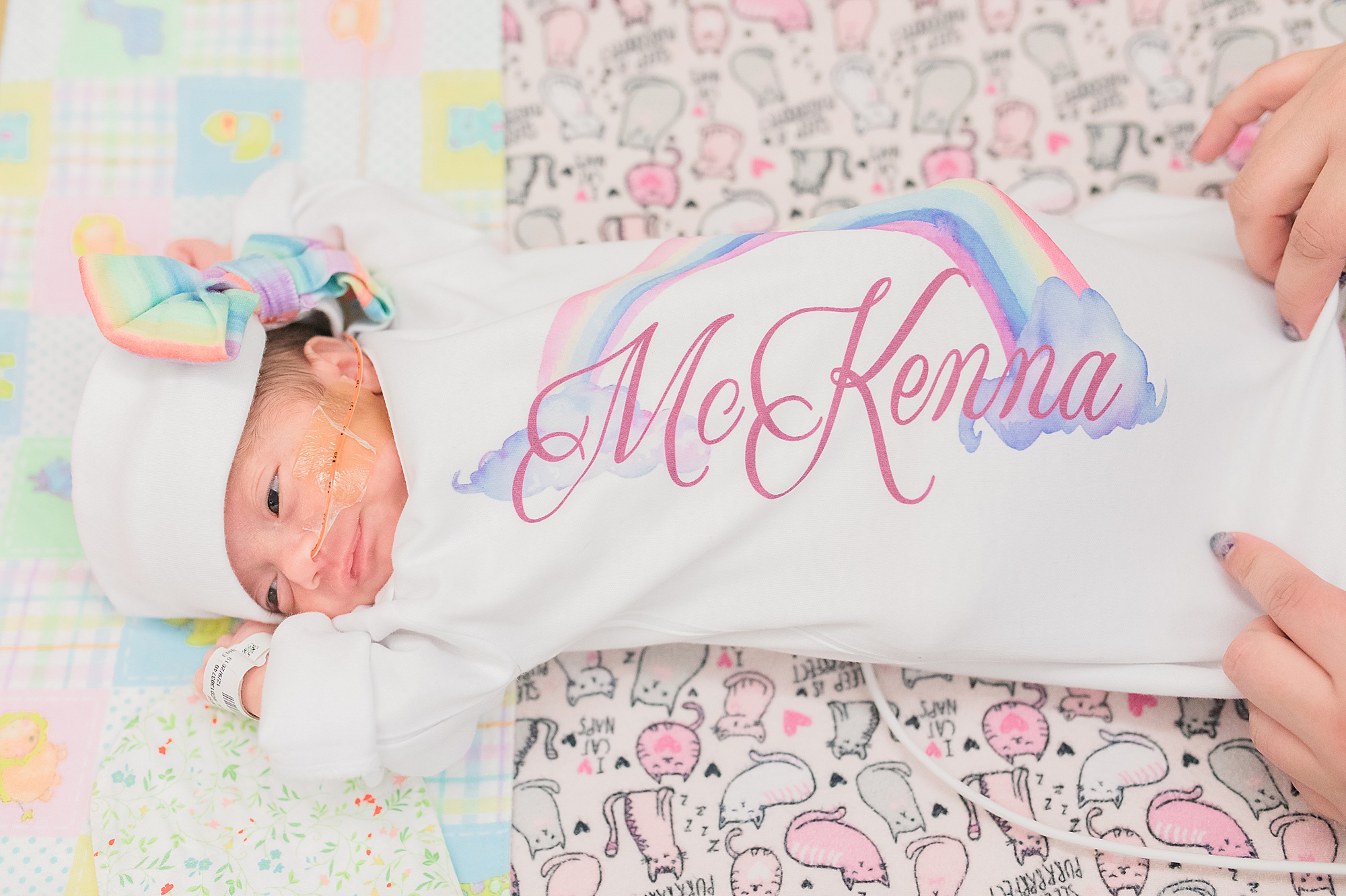 baby stretches out in rainbow outfit during NICU newborn portraits