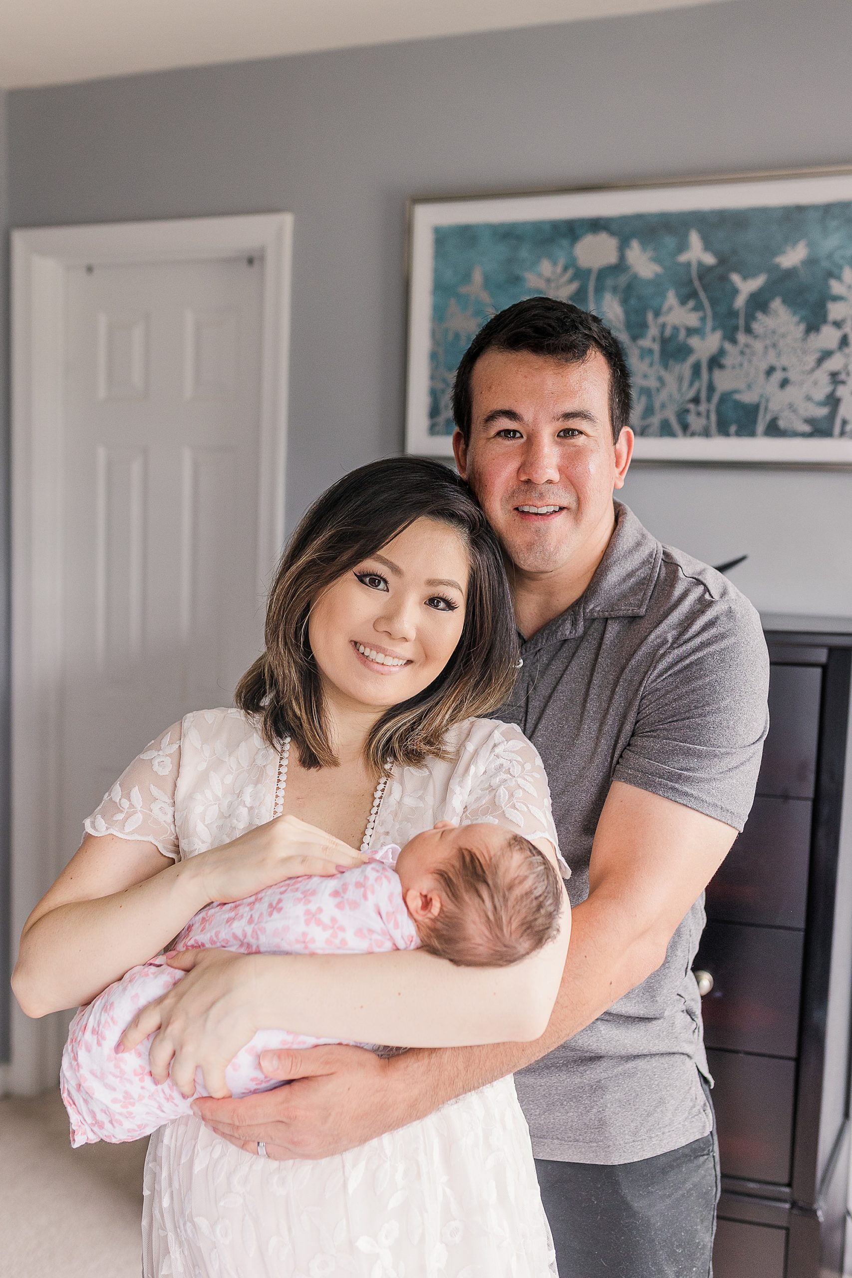 couple holds new baby girl at home during lifestyle newborn portraits