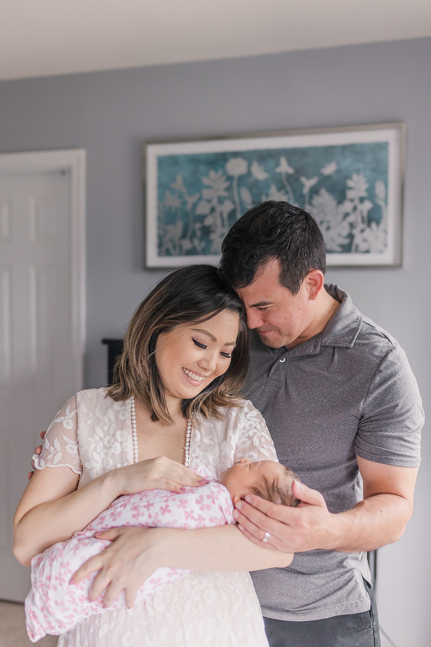 new parents hold baby girl during lifestyle newborn portraits