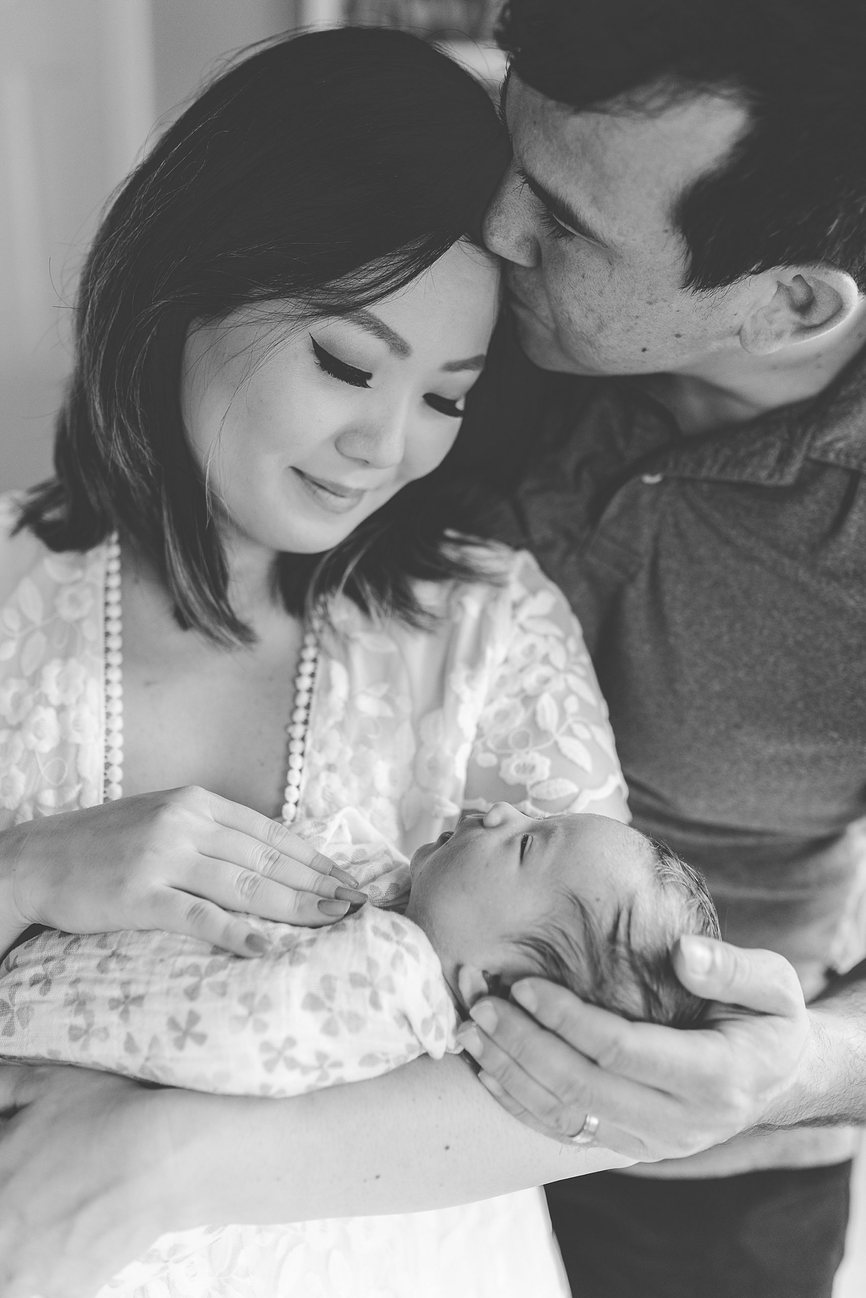 dad kisses wife's head during VA lifestyle newborn portraits