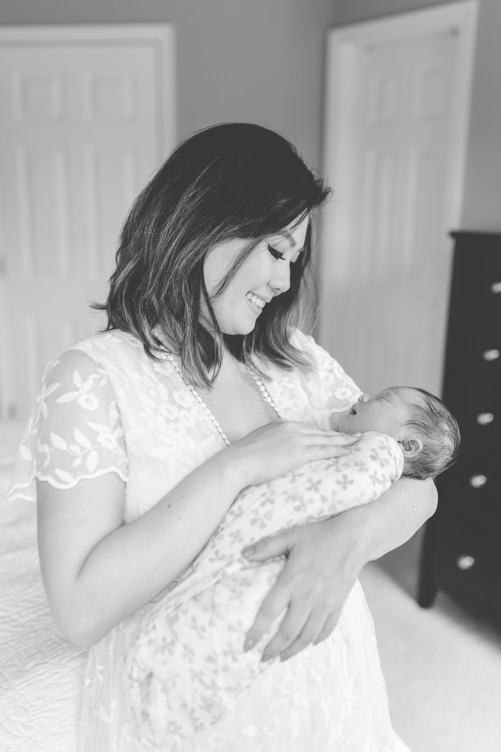 mom rocks daughter during lifestyle newborn portraits