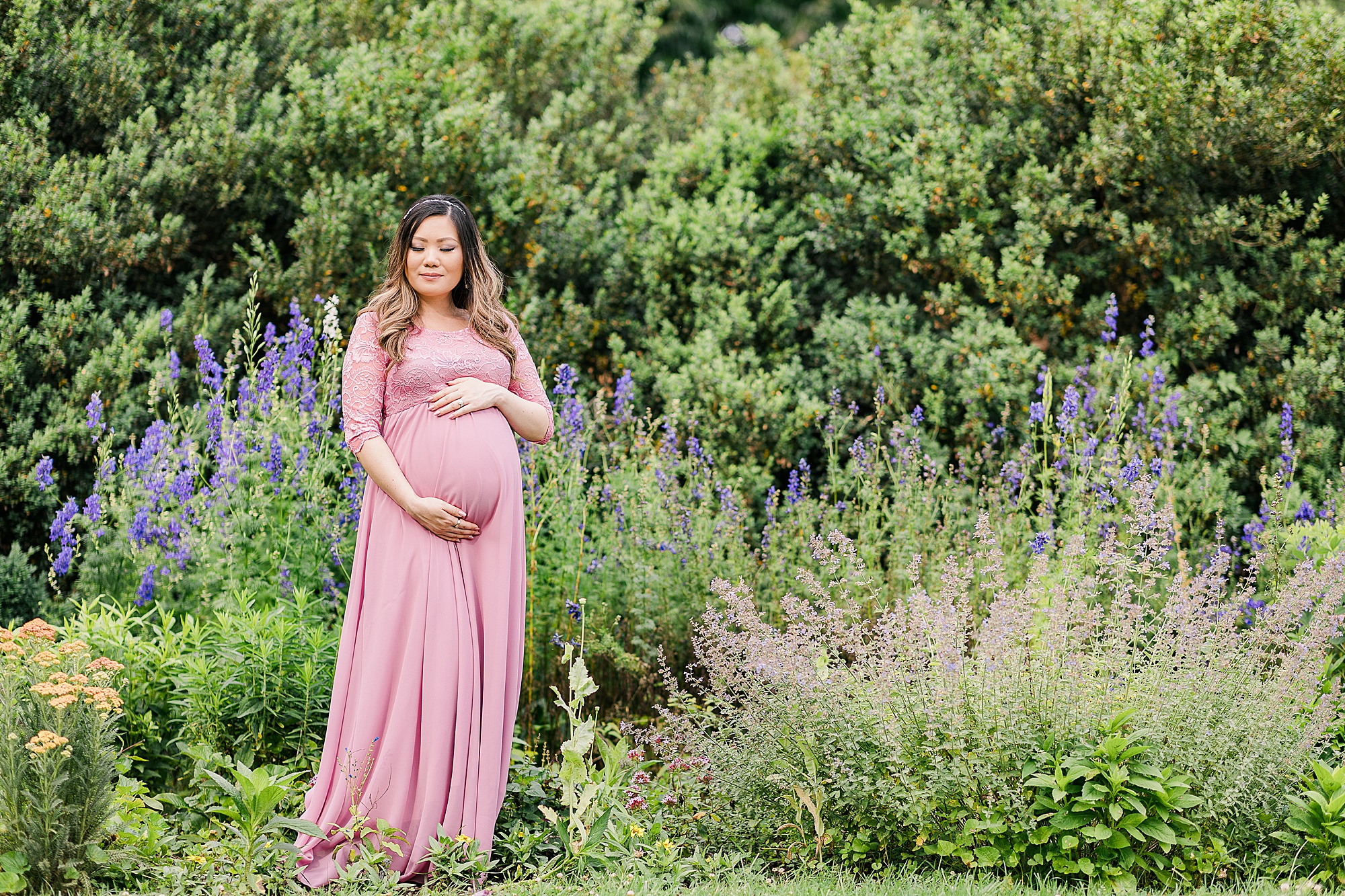 woman stands in garden during Green Spring Gardens maternity portraits 