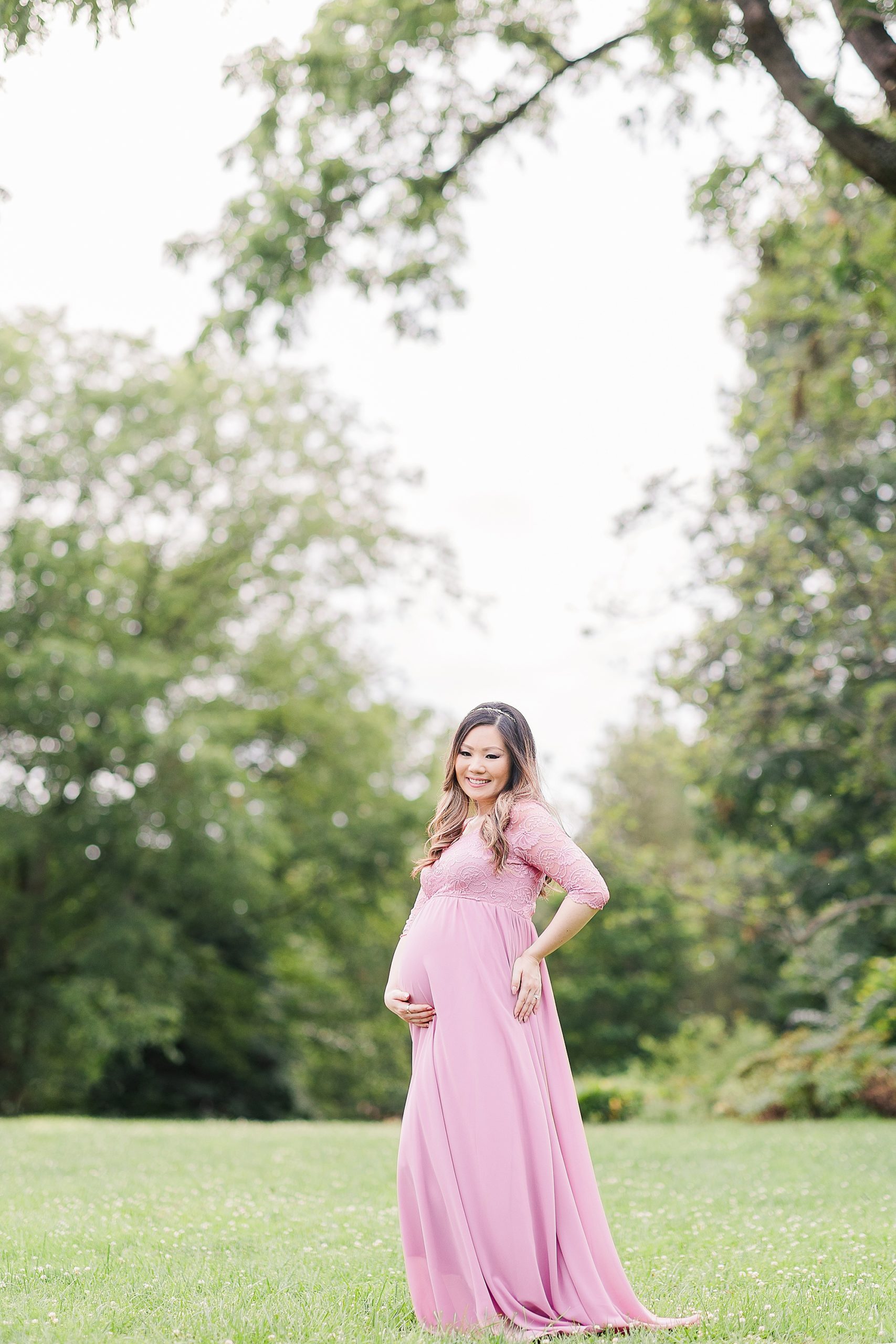 pregnant woman poses in pink gown at Green Spring Gardens