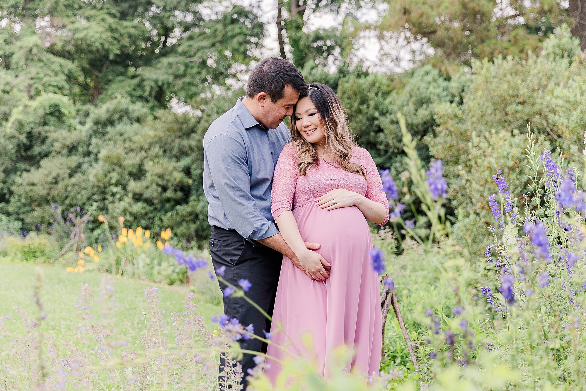 husband and wife hold woman's belly during Green Spring Gardens maternity session