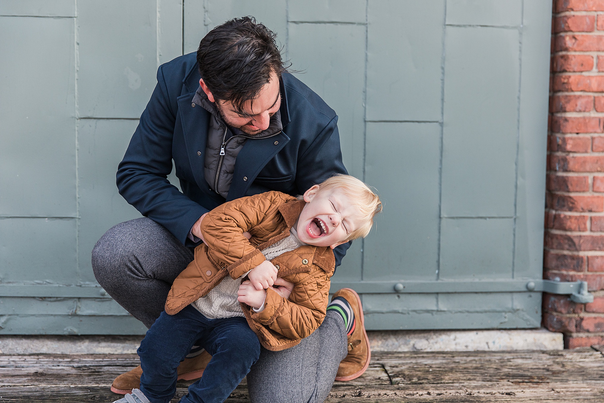 dad tickles son during Maryland family photos