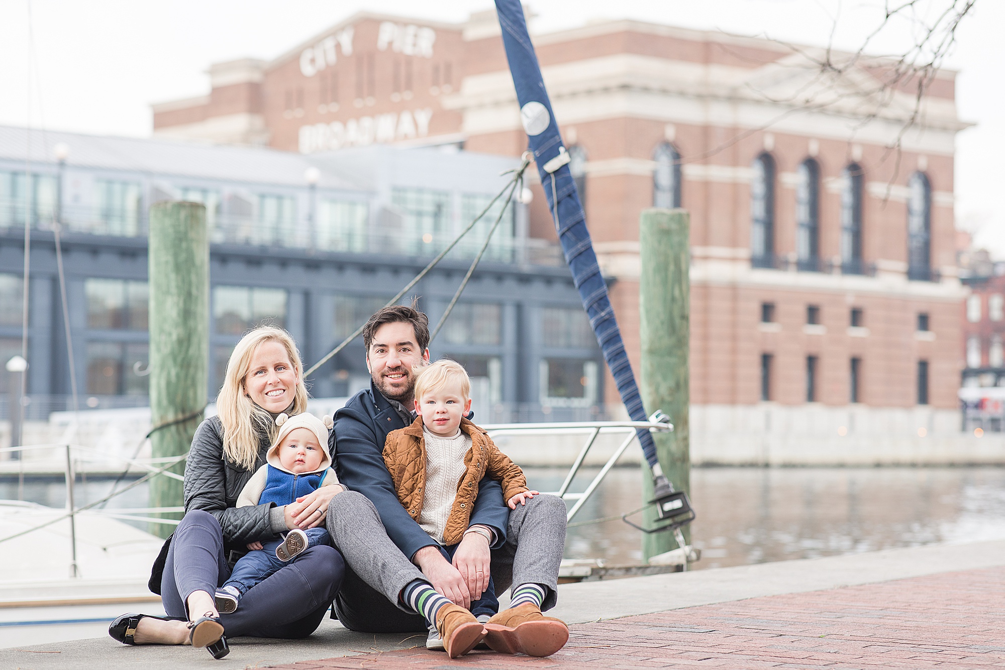 family poses by wharf in Fells Point MD