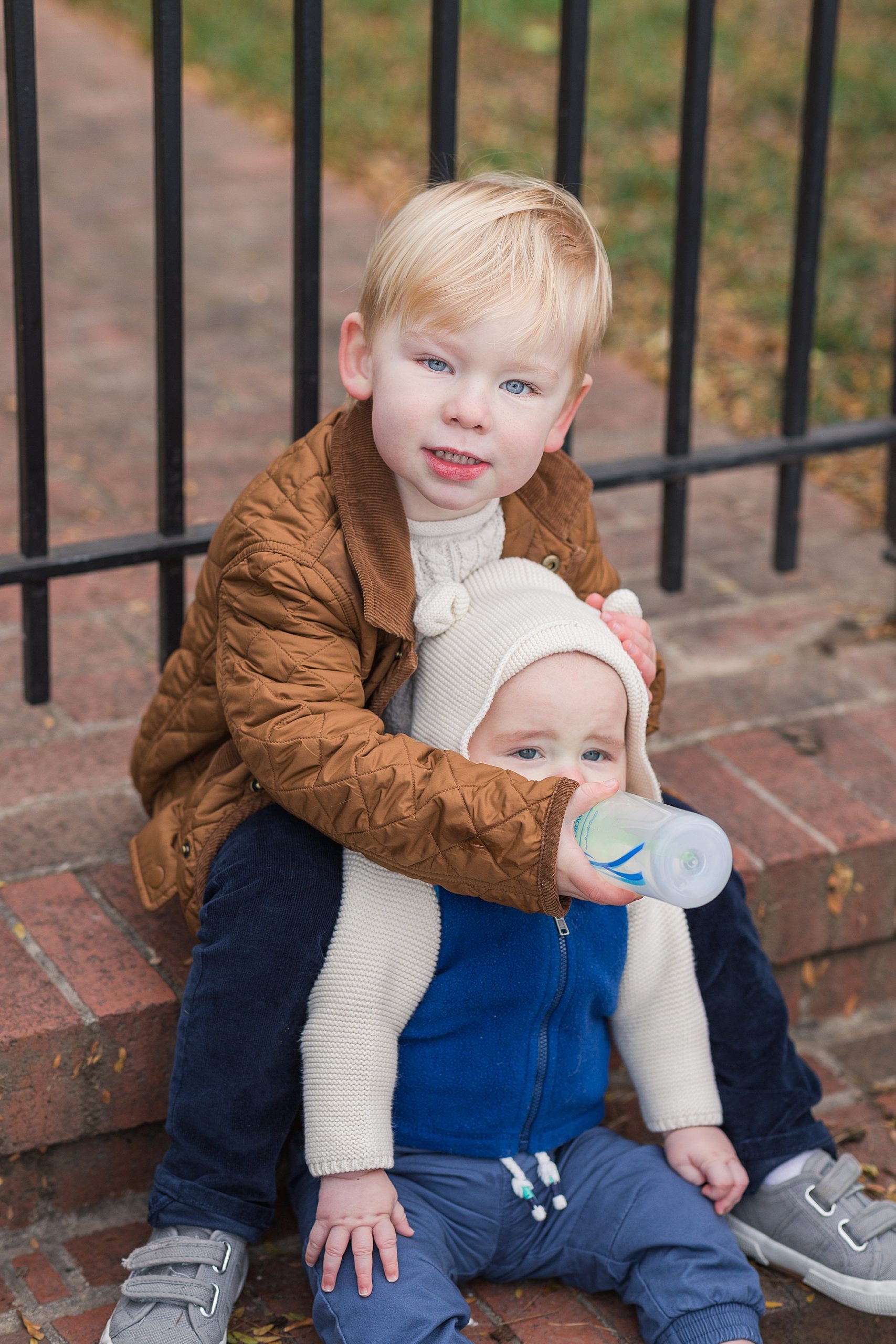 brother feeds sister during winter family photos in Fells Point MD 