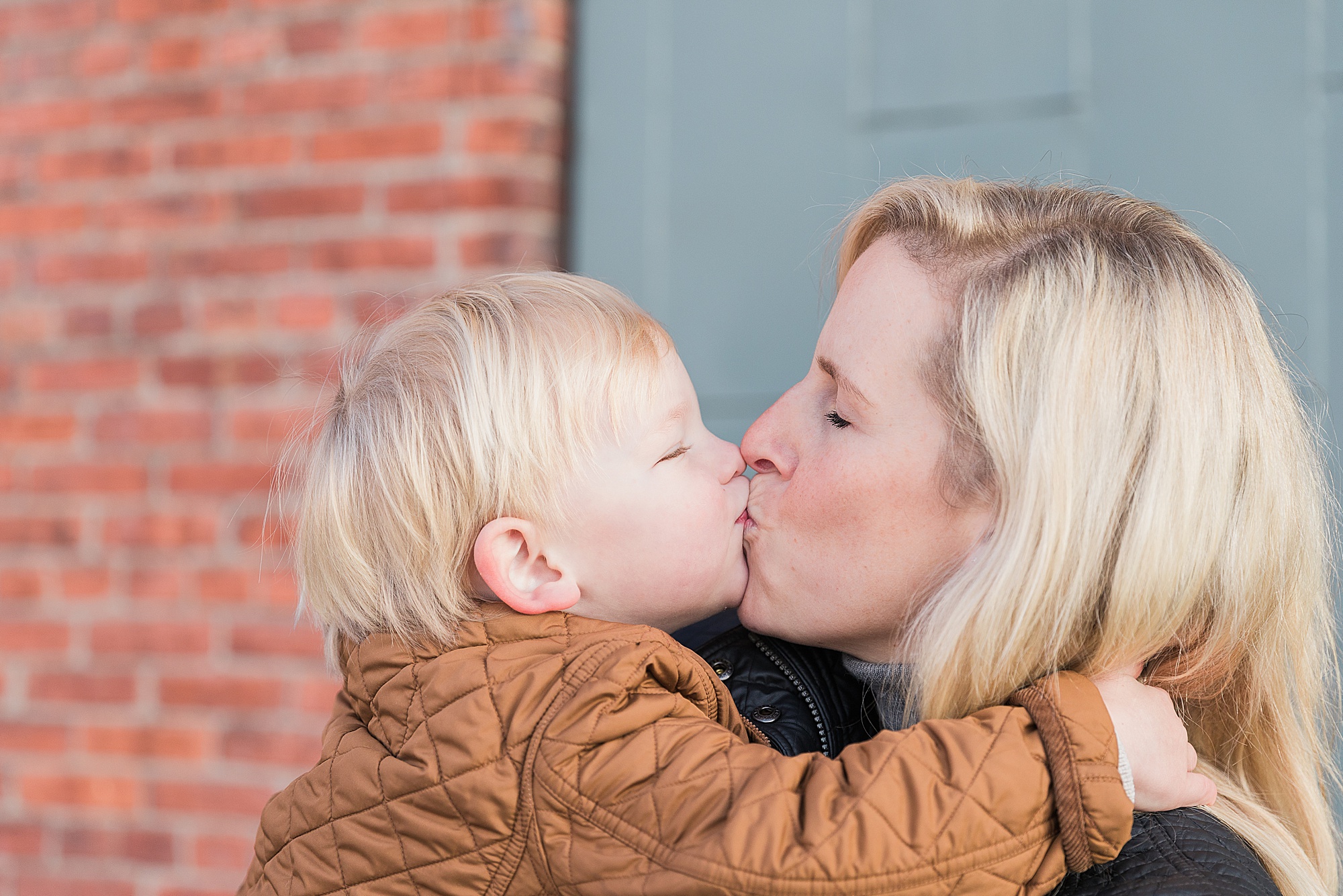 toddler kisses mom during Fells Point family portraits 
