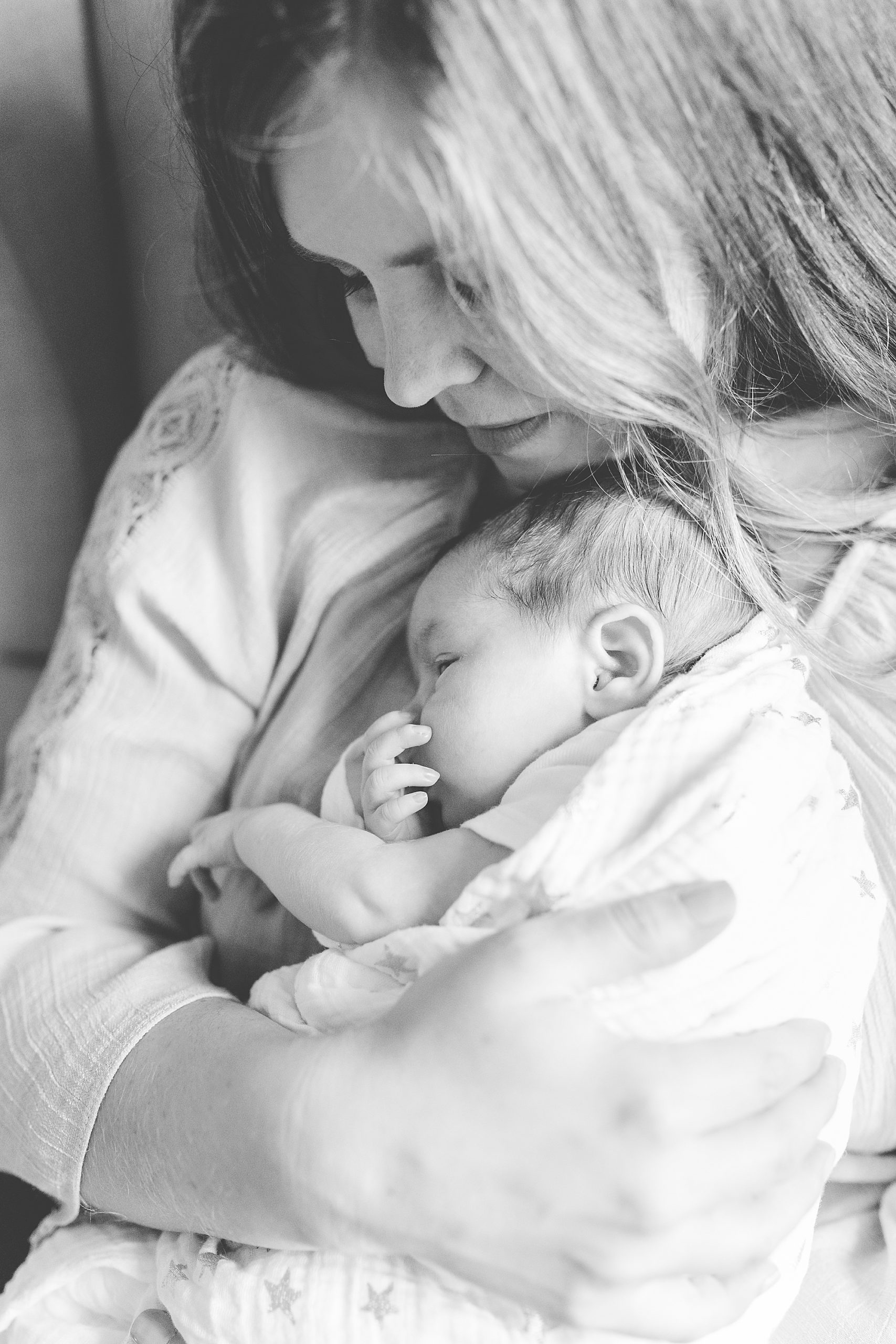 mom holds baby against chest during Annapolis lifestyle newborn session