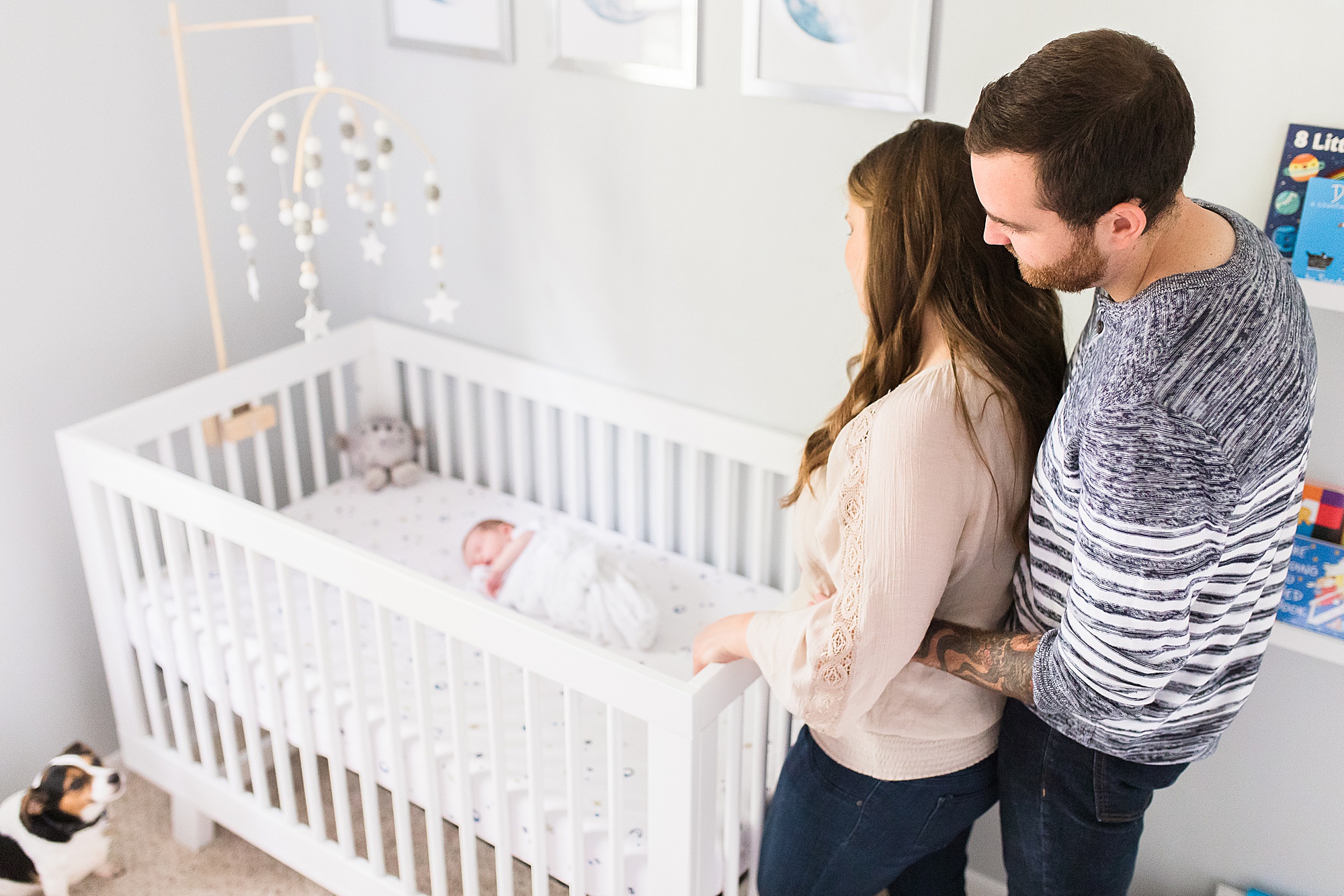 parents look down at baby in crib during Annapolis lifestyle newborn session
