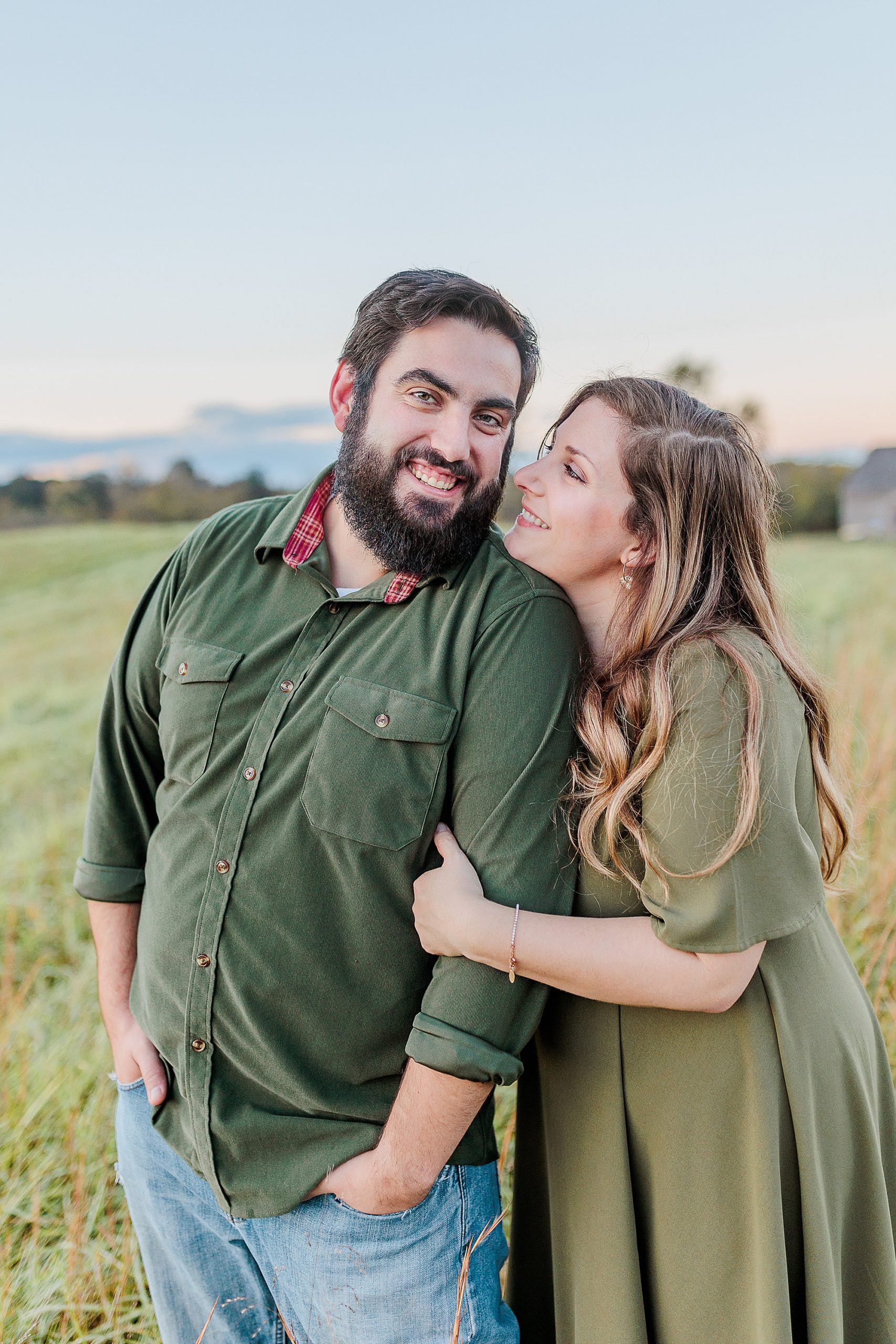 parents hug during portraits in field at Howard County Conservancy