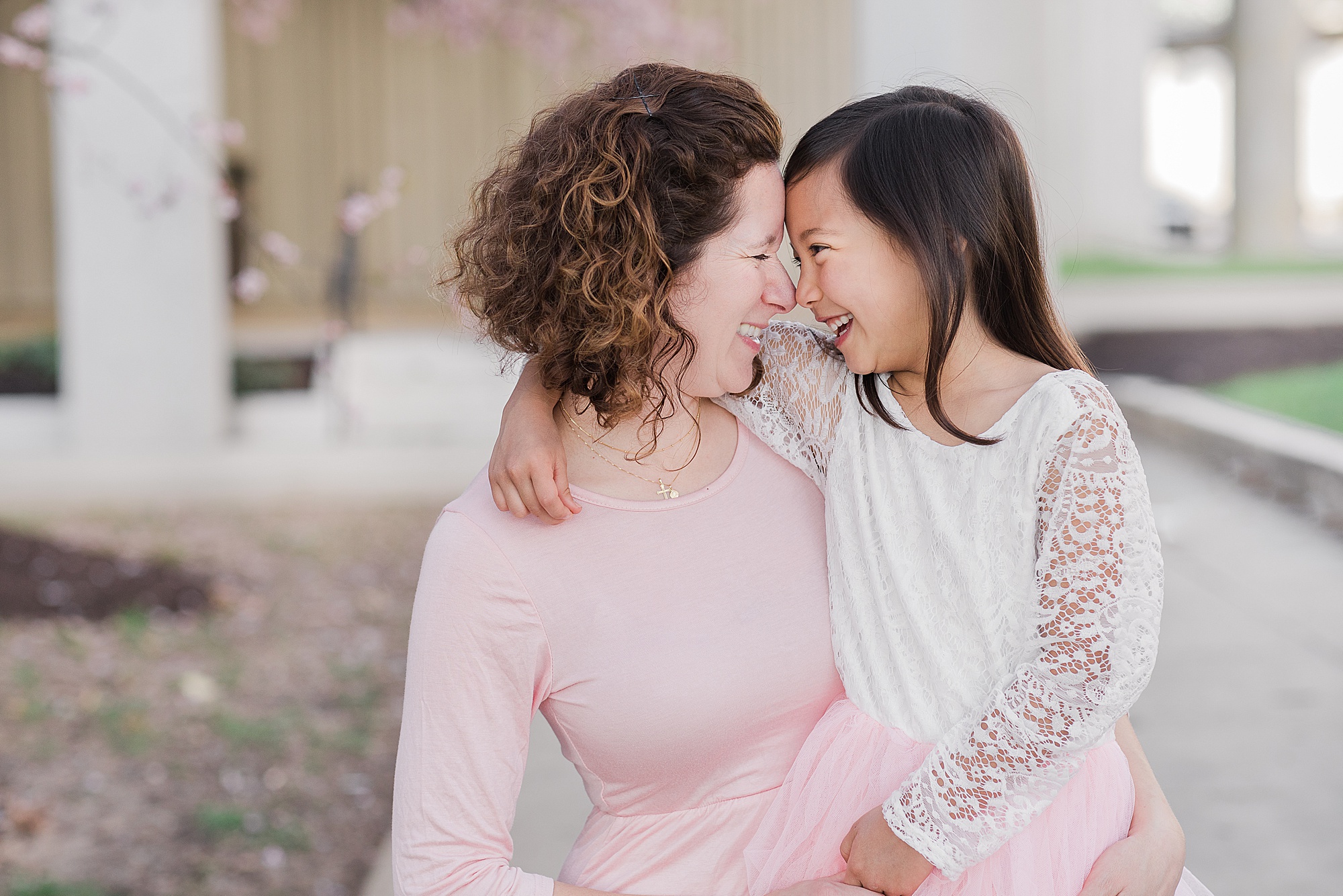 mom and daughter hug during cherry blossom portraits 