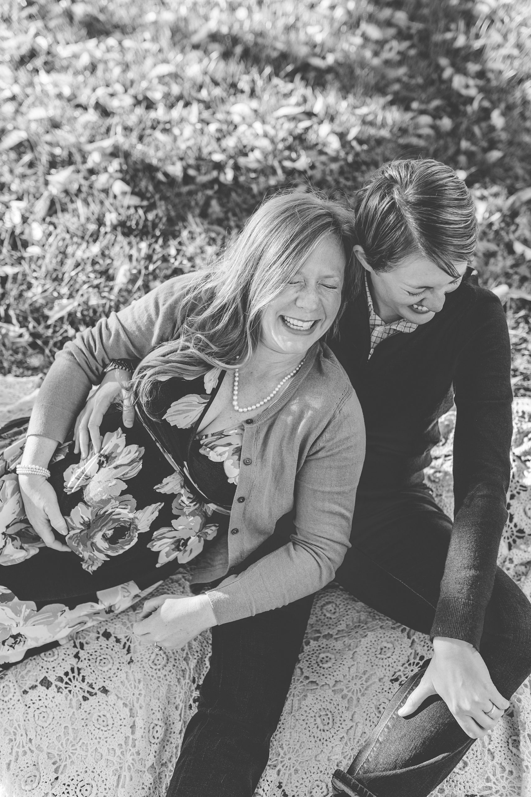 same-sex couple laughs during maternity portraits in Maryland 