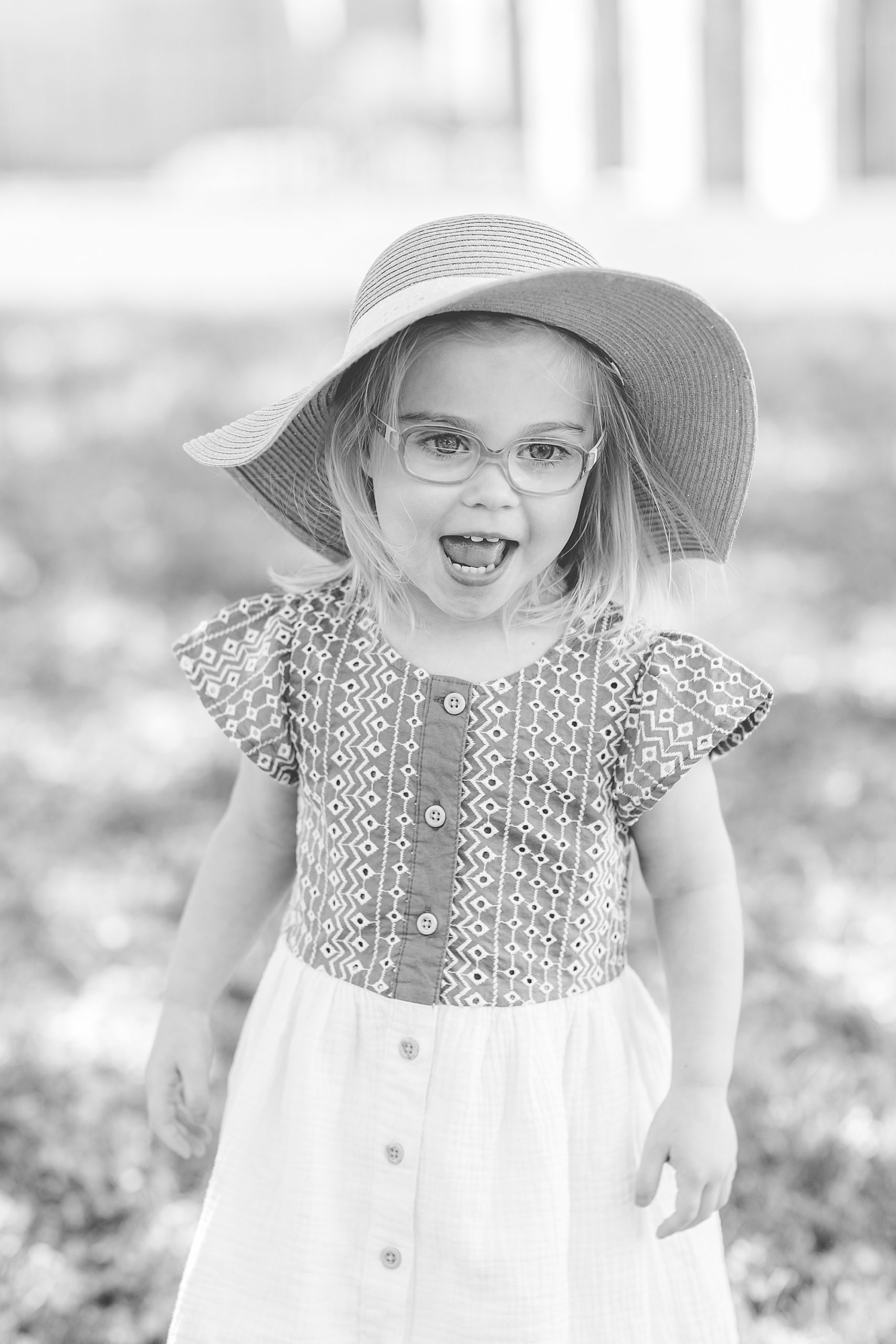 toddler plays in floppy hat for spring photos 