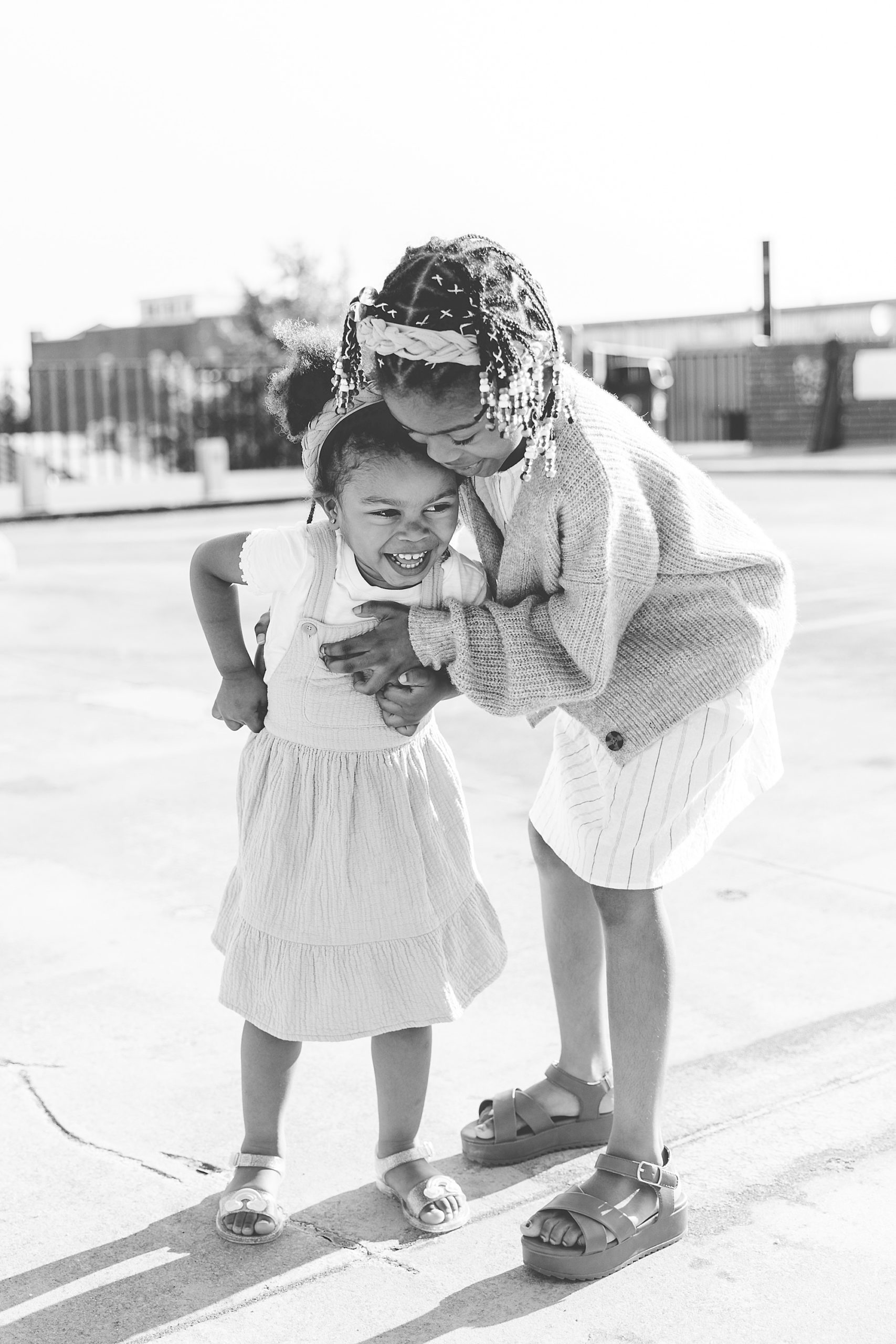 sisters hug on top of parking garage during Annapolis family portraits