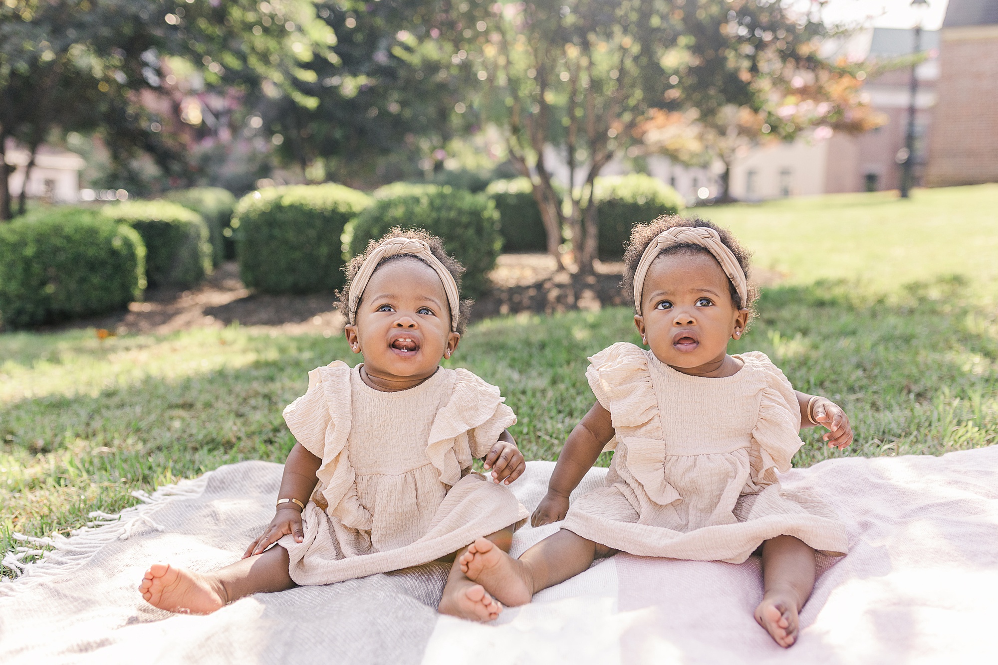 twin girls sit on blanket in grass during Annapolis family portraits