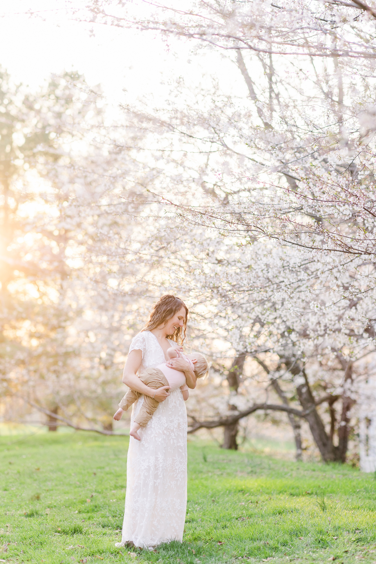 mother holds baby in white gown from client closet