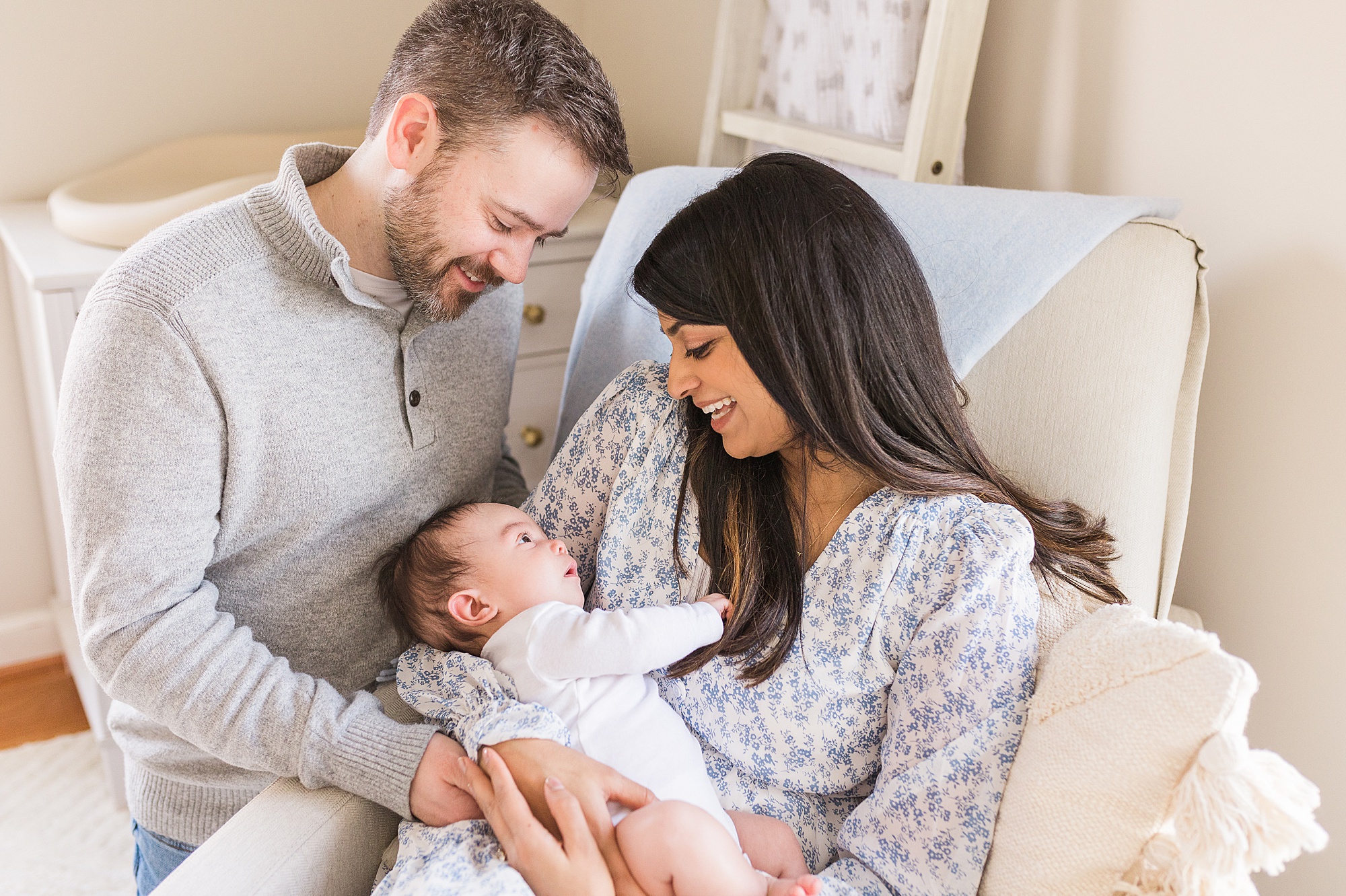 parents look down at baby during cozy lifestyle newborn session