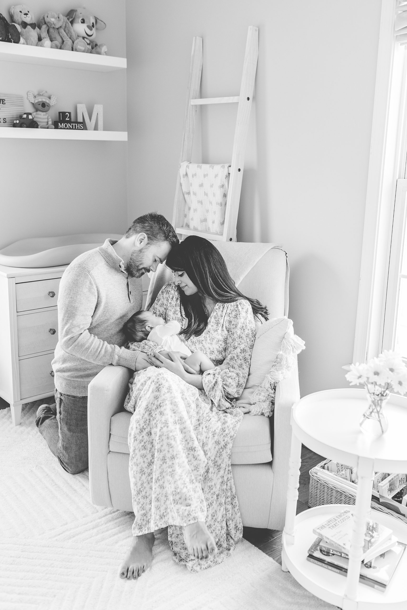parents hold son in rocker during newborn photos at home 