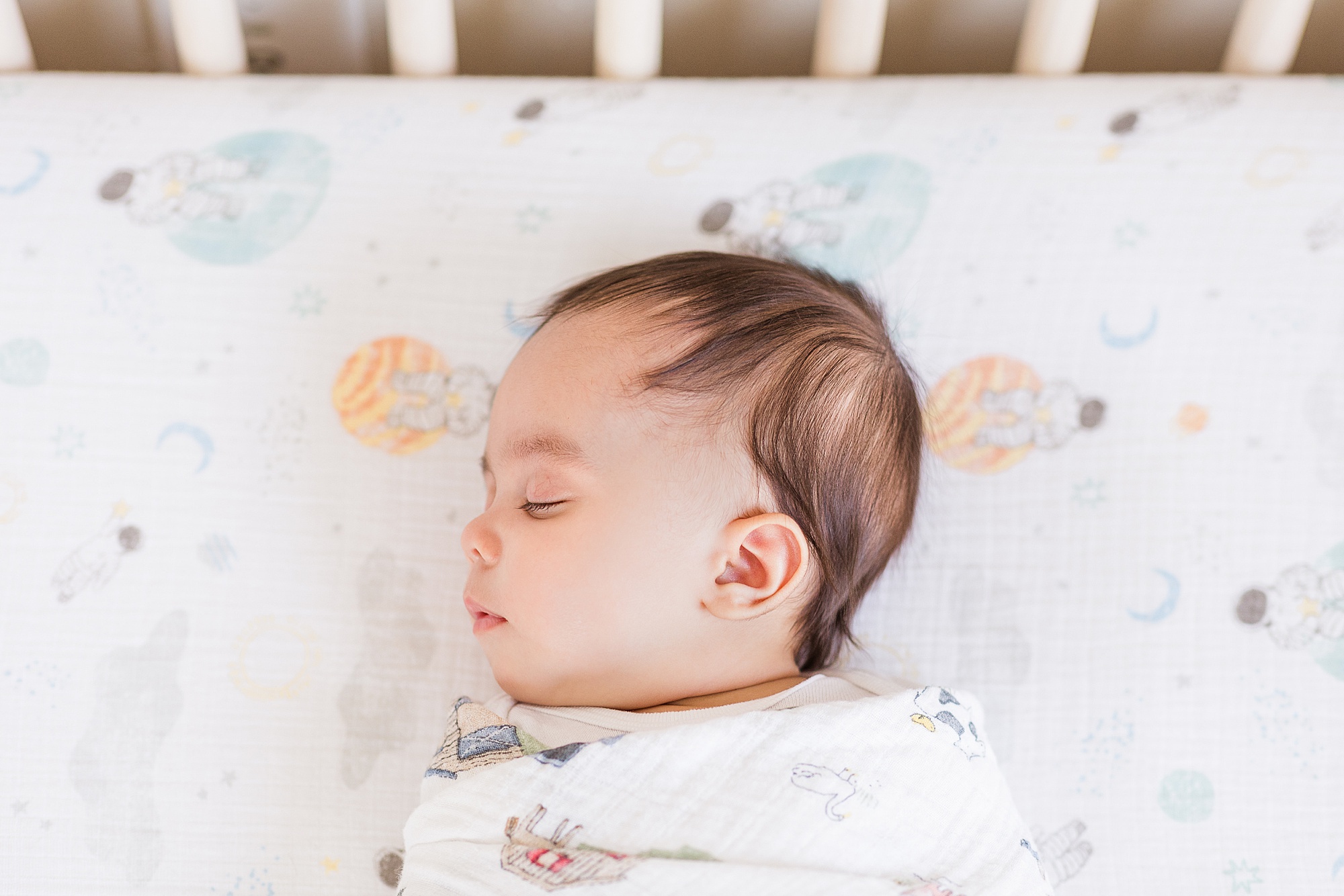 baby boy sleeps in crib during lifestyle newborn session