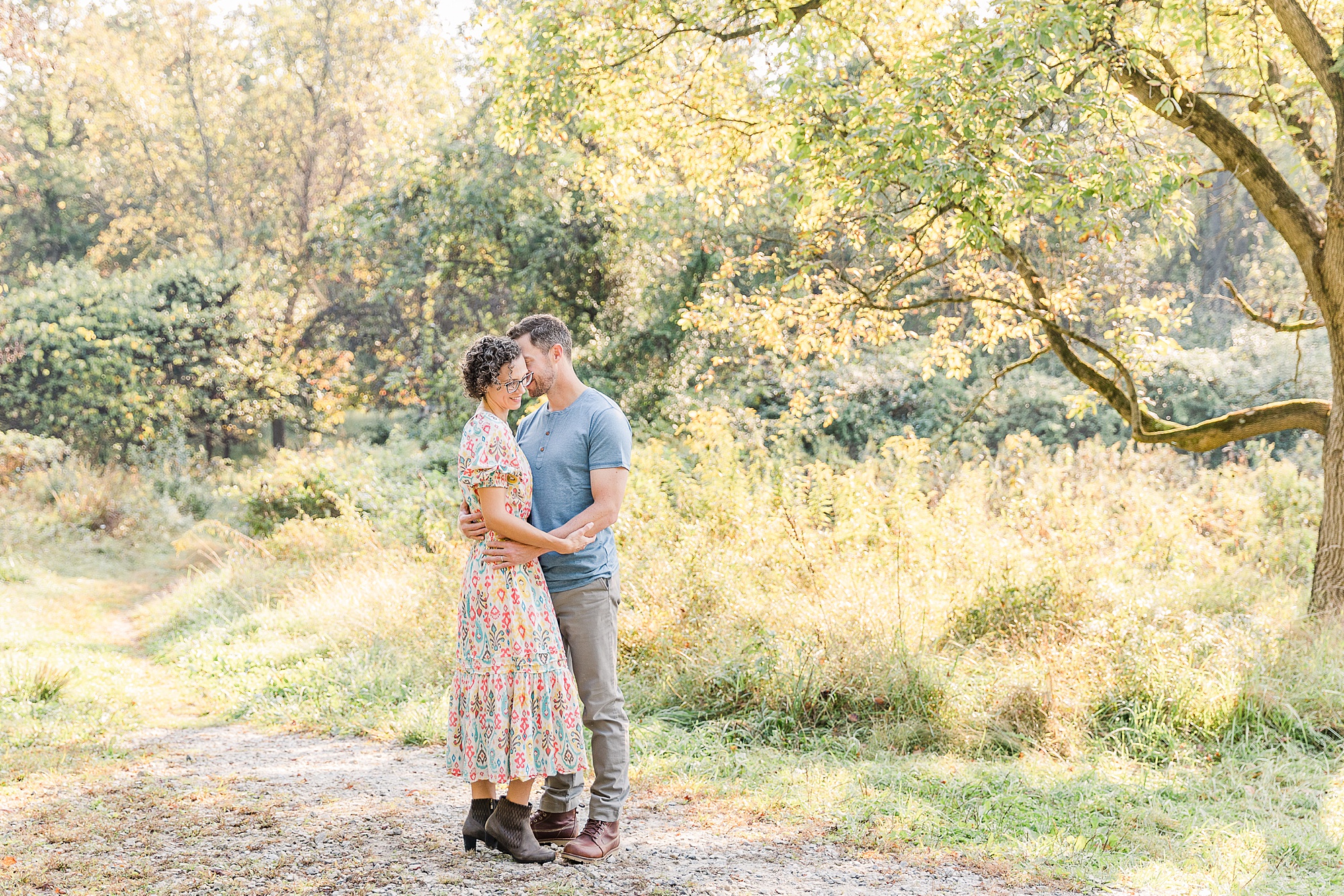 couple poses together in field during fall minis in Maryland