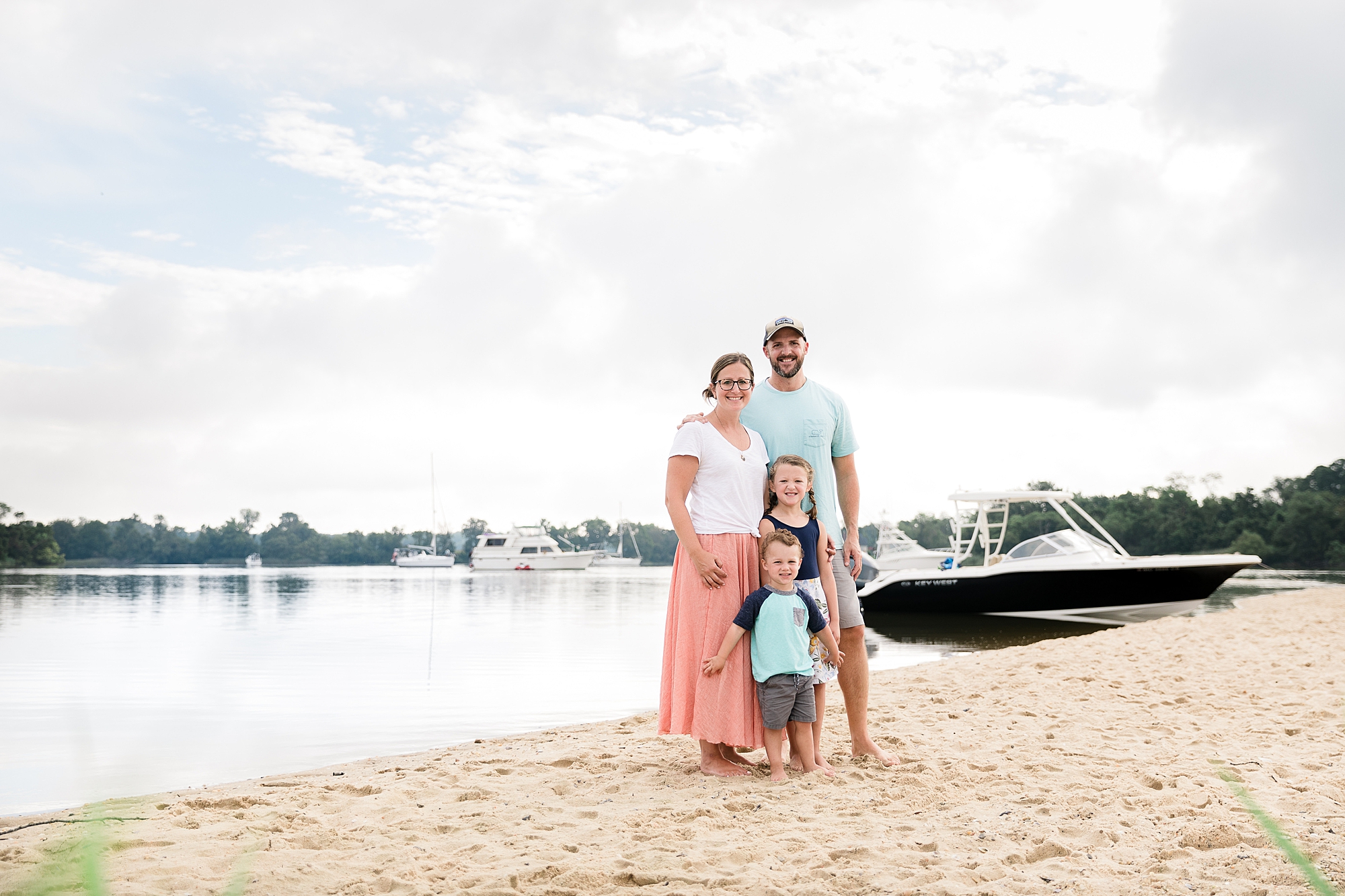 parents stand with two kids on sandy point beach during Chesapeake Beach Family Portraits